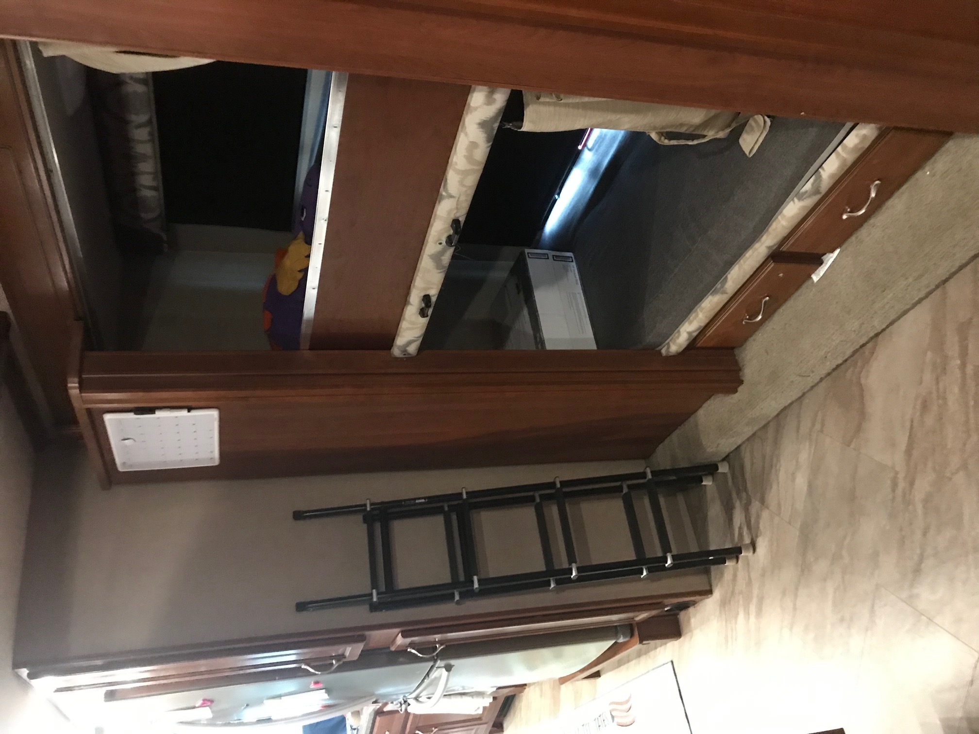 This RV rental features a compact sleeping area with bunk beds, a ladder, and wooden cabinetry, maximizing space for travelers.. Fleetwood Bounder 2016