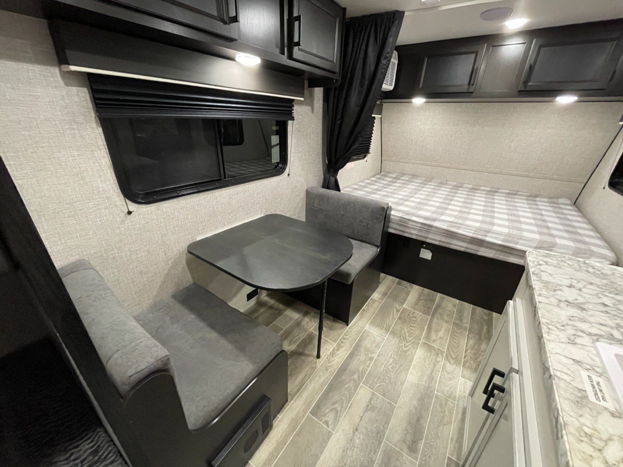 Cozy RV rental interior with dinette seating, comfortable bed, and overhead storage, ideal for road trips.. Jayco Jay Flight SLX 2022