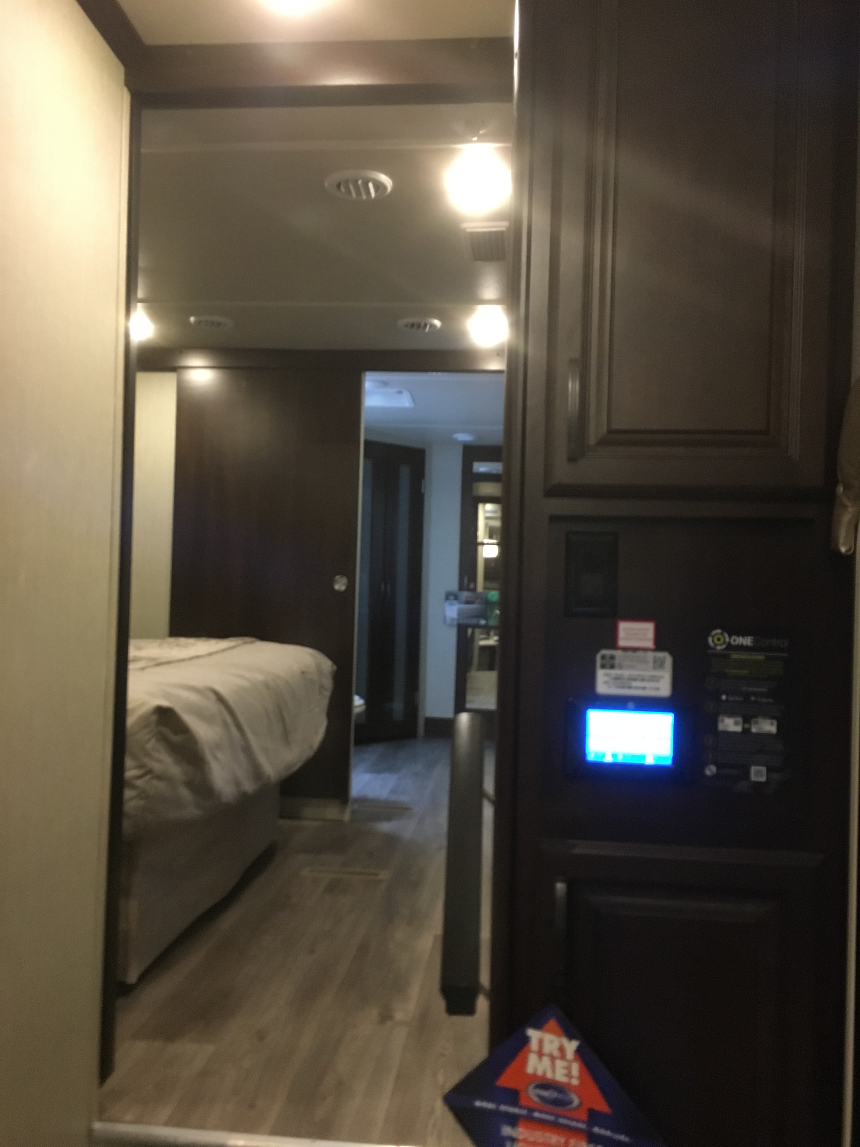 RV rental interior: bedroom view from hallway, showing a modern control panel on dark cabinetry. Well-lit compact space.. Forest River Palomino Columbus 2018