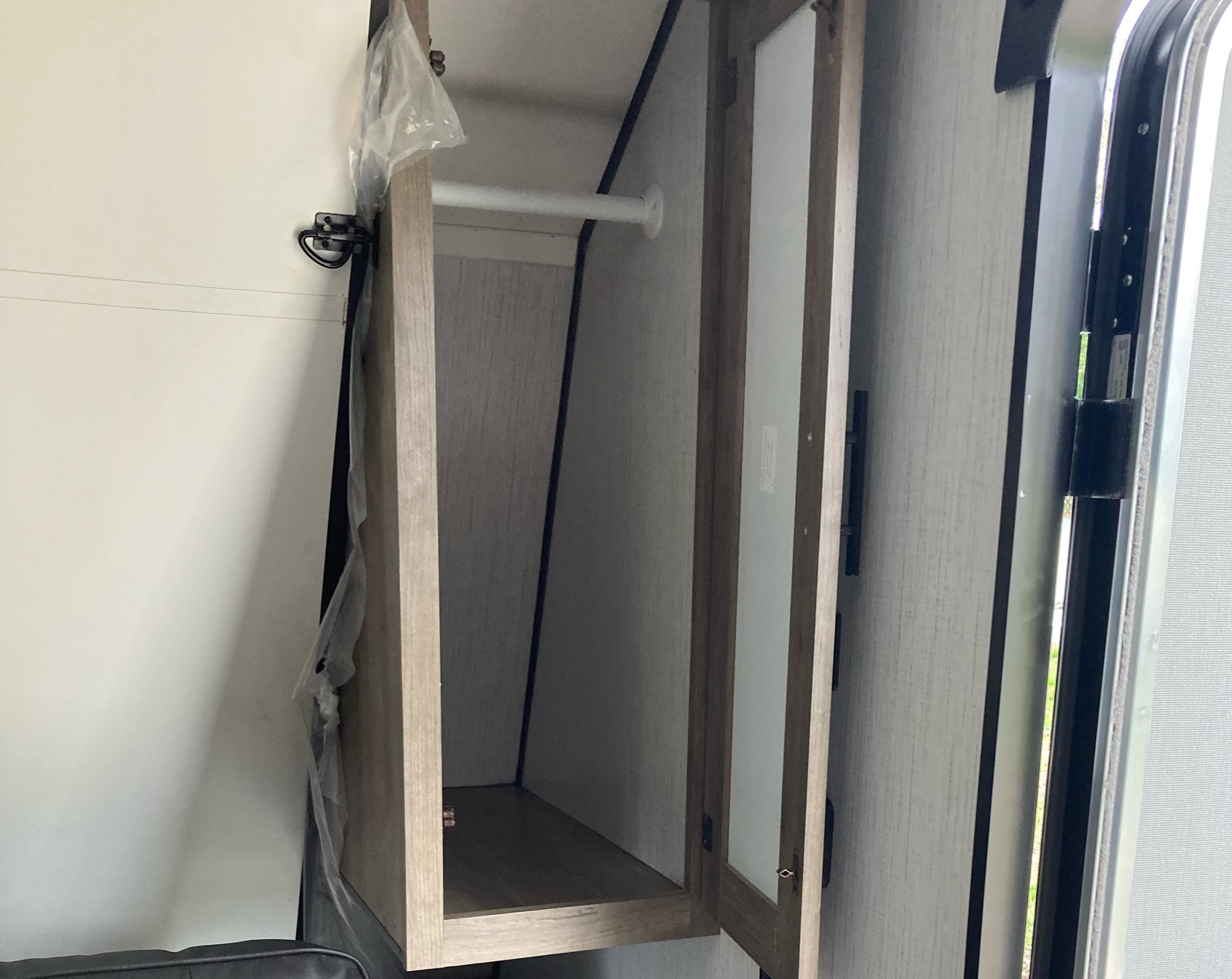 RV rental interior: Open camper closet with a hanging rod for clothes, alongside the RV entry door.. Heartland RVs Pioneer Trail Blazer 2022