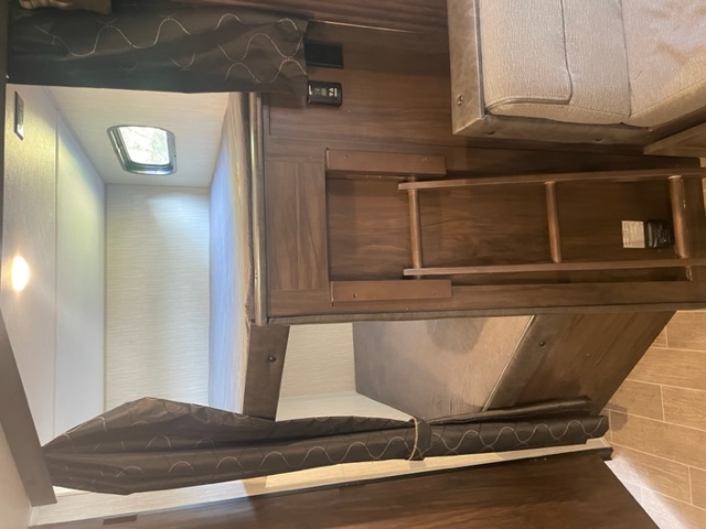 RV rental: Interior showing bunk beds with ladder & privacy curtain. Cozy space for family trips.. Forest River Cherokee Alpha Wolf 2021