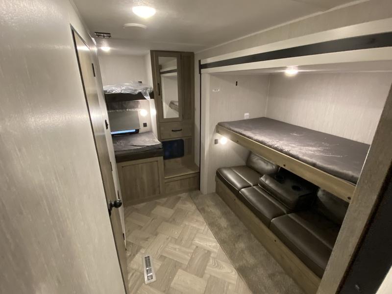 RV rental bunkhouse: A spacious interior with multiple bunk beds and lounge seating, ideal for groups.. Forest River Palomino Puma 2022