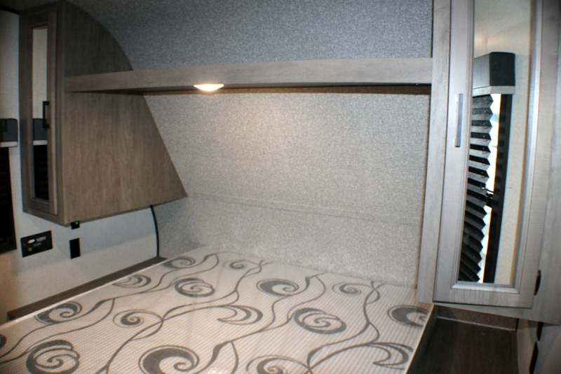 Modern RV rental bedroom with patterned mattress, overhead storage, and reading light. Ideal for comfortable travel.. Open Range Open Range 2022