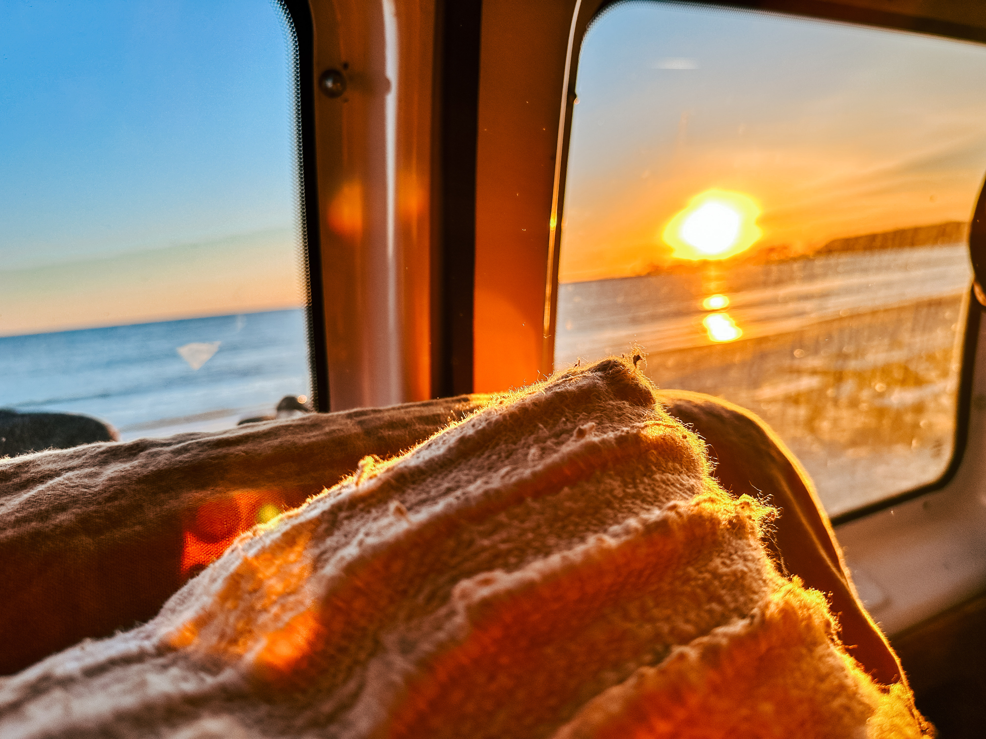 Experience stunning sunsets from your RV rental. Golden light bathes a cozy blanket and reflects on the ocean horizon.. Ford E350 2008