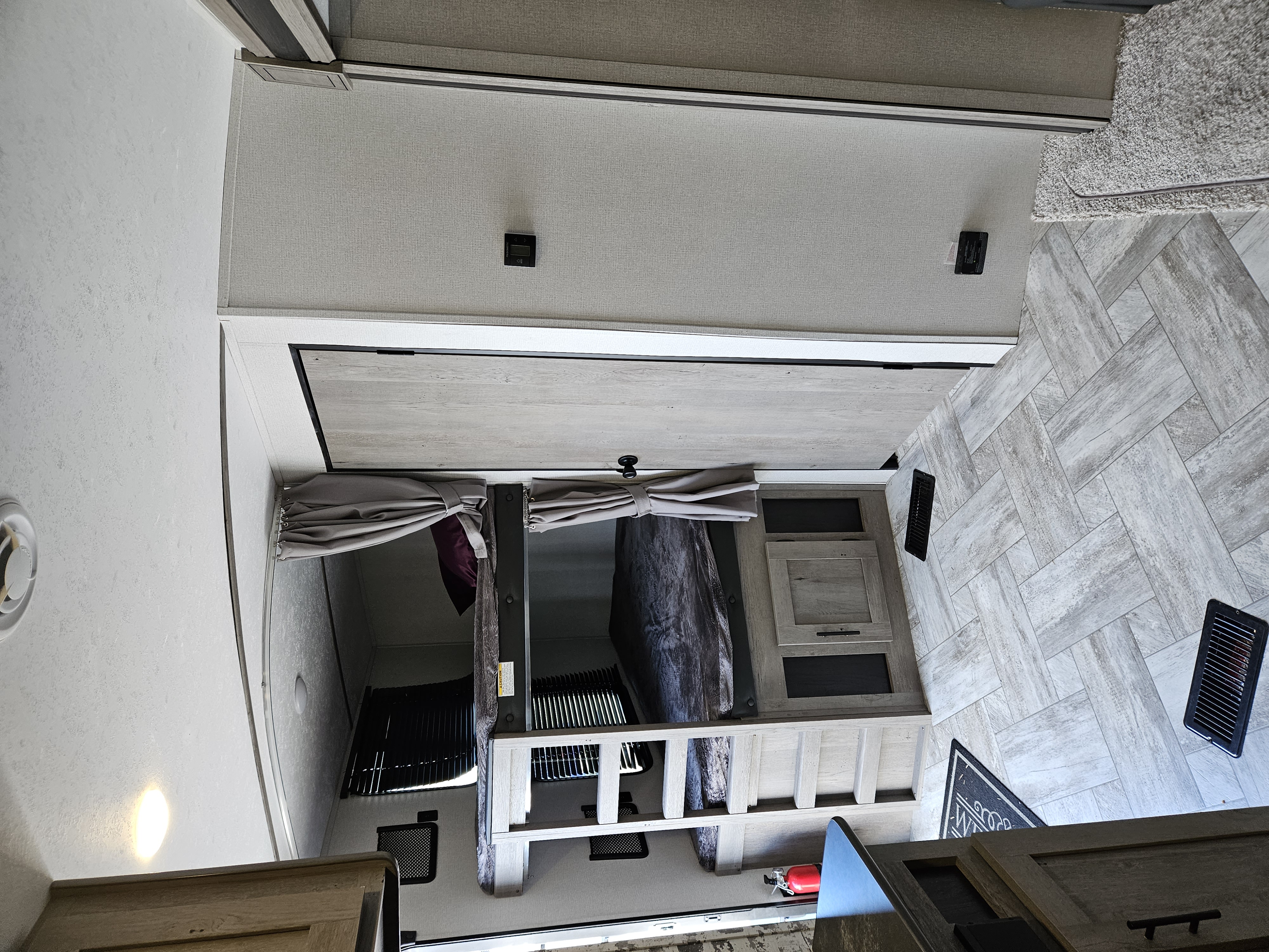 Explore this RV rental's interior! Features cozy bunk beds, stylish wood-look flooring, and functional storage space.. Keystone RV Springdale 2022