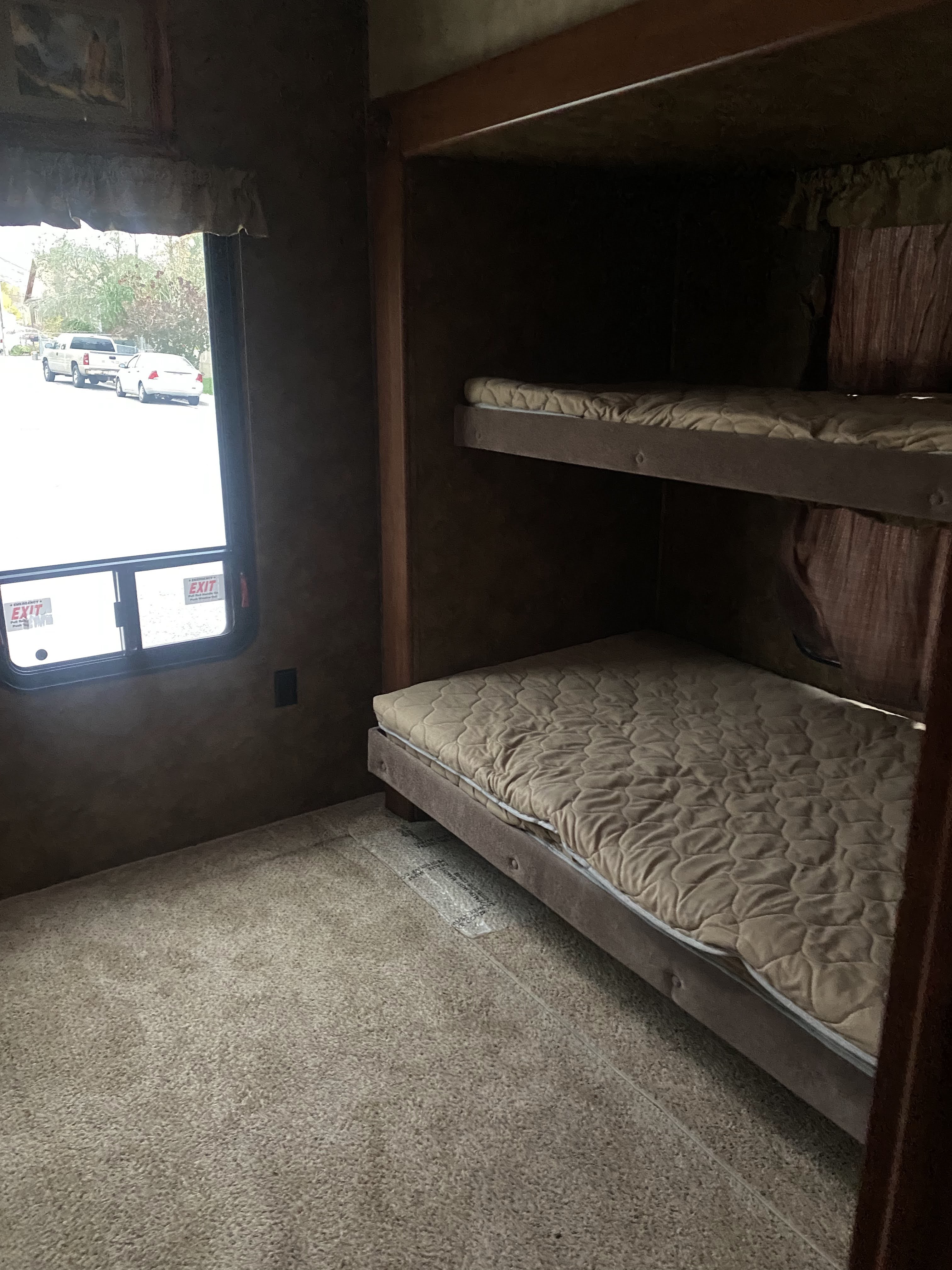 RV rental interior: Cozy bunk beds and a window view from inside this camper's sleeping area.. Forest River Sandpiper 2013