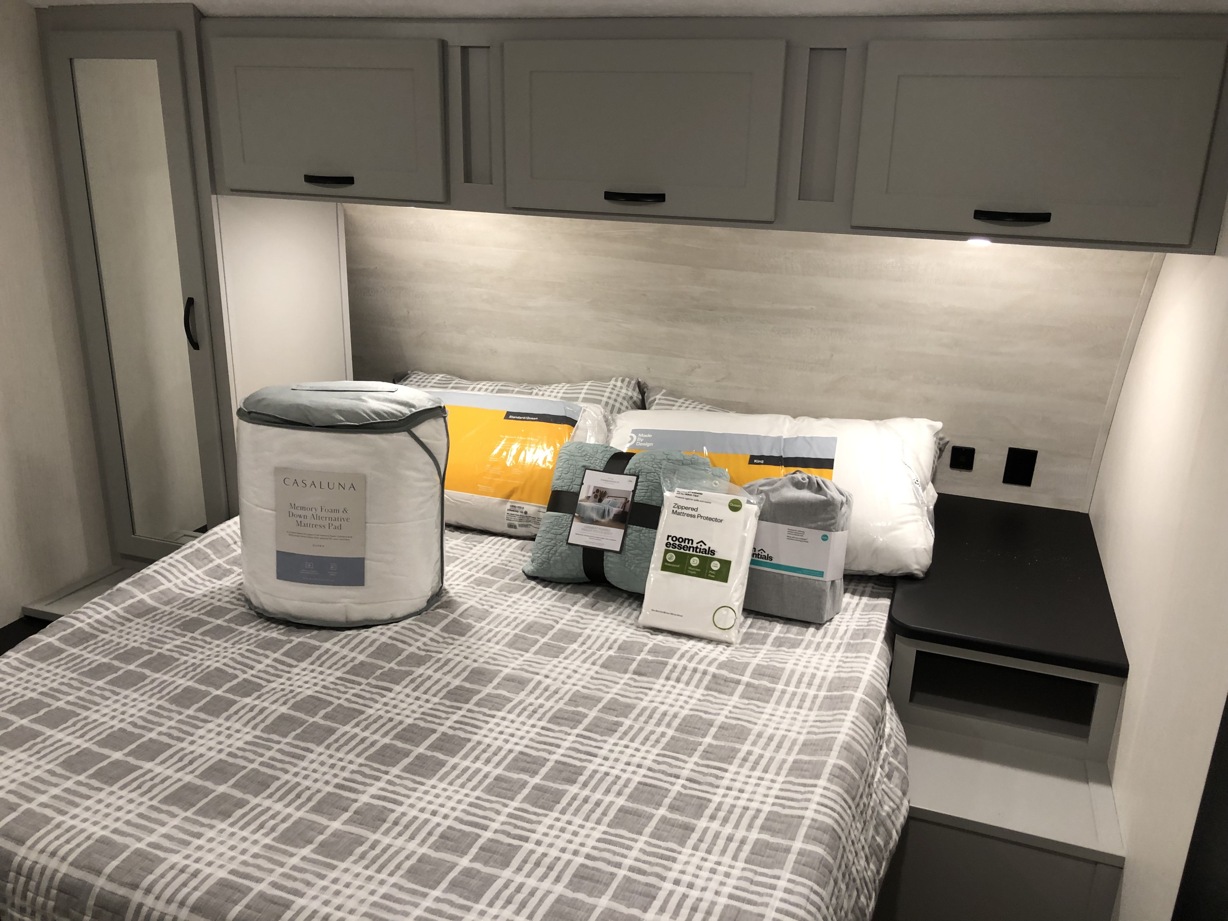 This modern RV rental bedroom offers new bedding, including a mattress pad, pillows, and cozy blankets, plus ample storage.. Forest River Vibe 2022