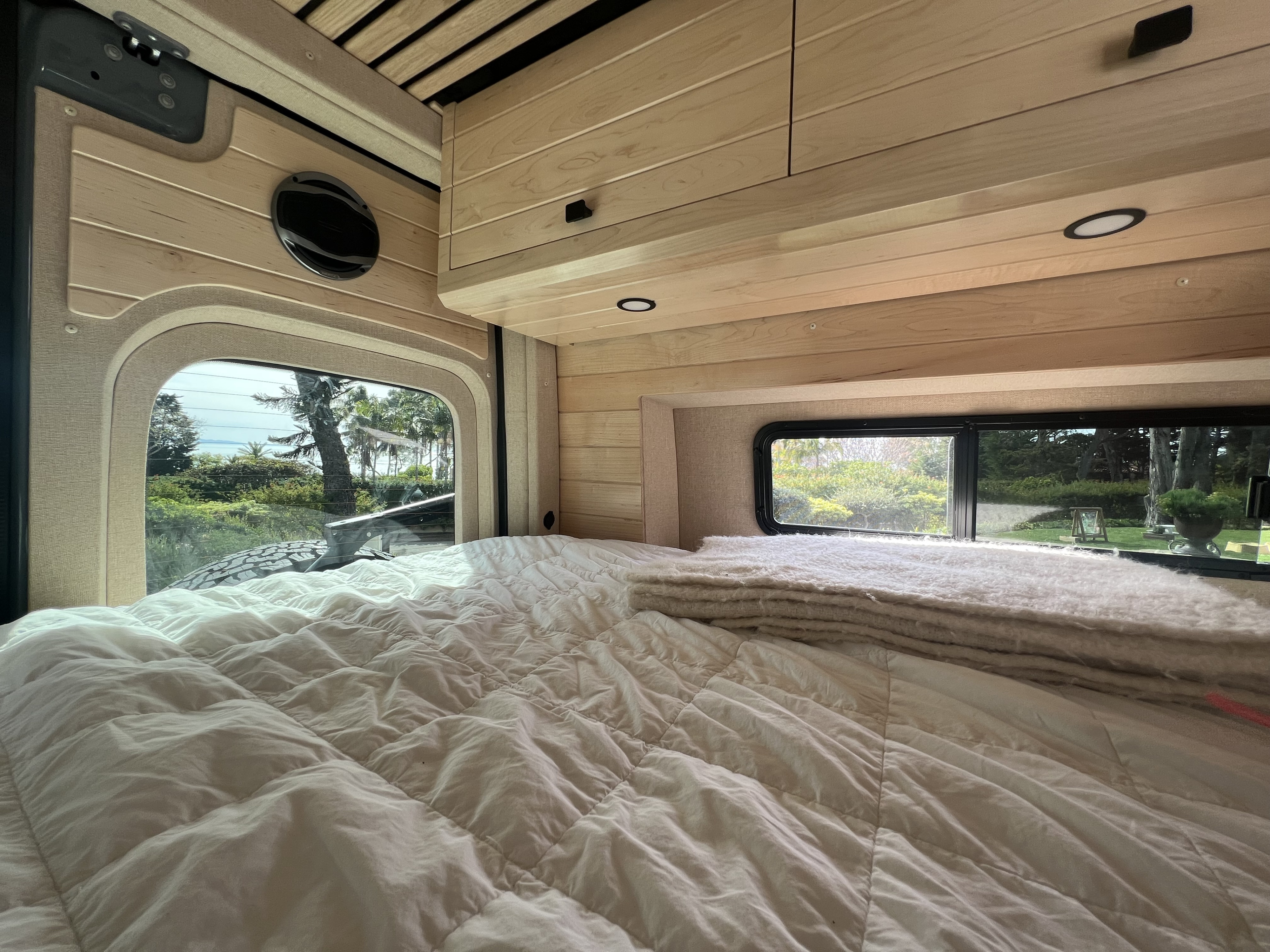 RV rental interior: cozy bed, wood finishes, and scenic windows for your next adventure.. Mercedes Sprinter 2022