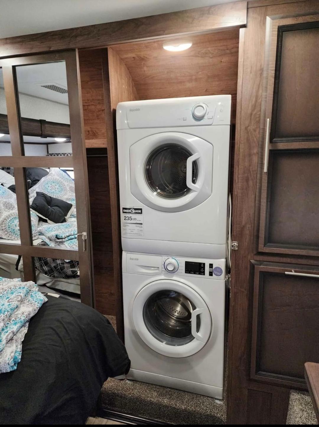 RV rental with a convenient stacked washer/dryer unit visible. Wood interior & mirrored closet for efficient RV laundry.. KZ Durango 2021