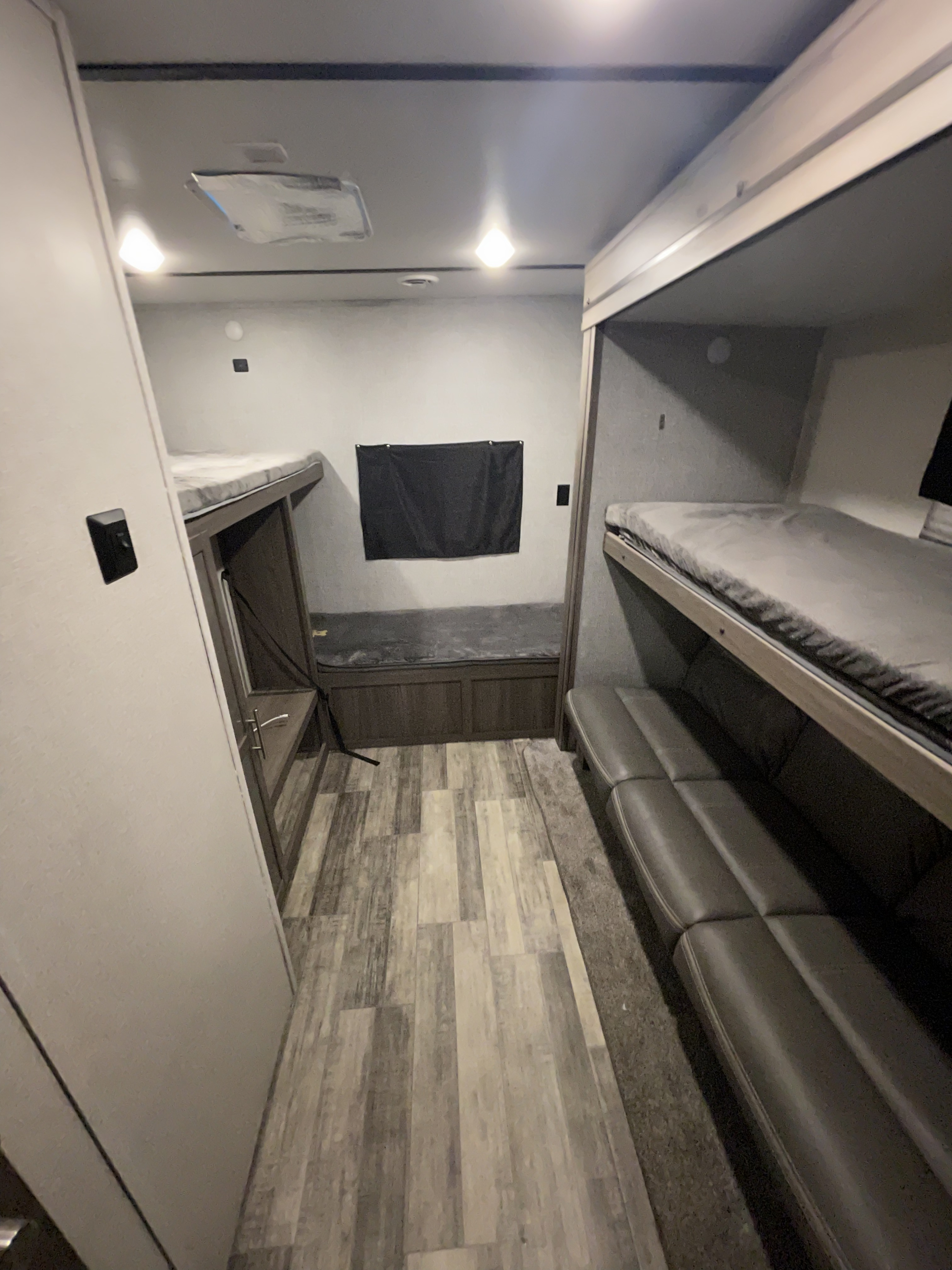 RV rental bunkhouse with multiple bunk beds, sofa seating, and wood-look flooring for comfortable camper stays.. Crossroads RV Volante 2021