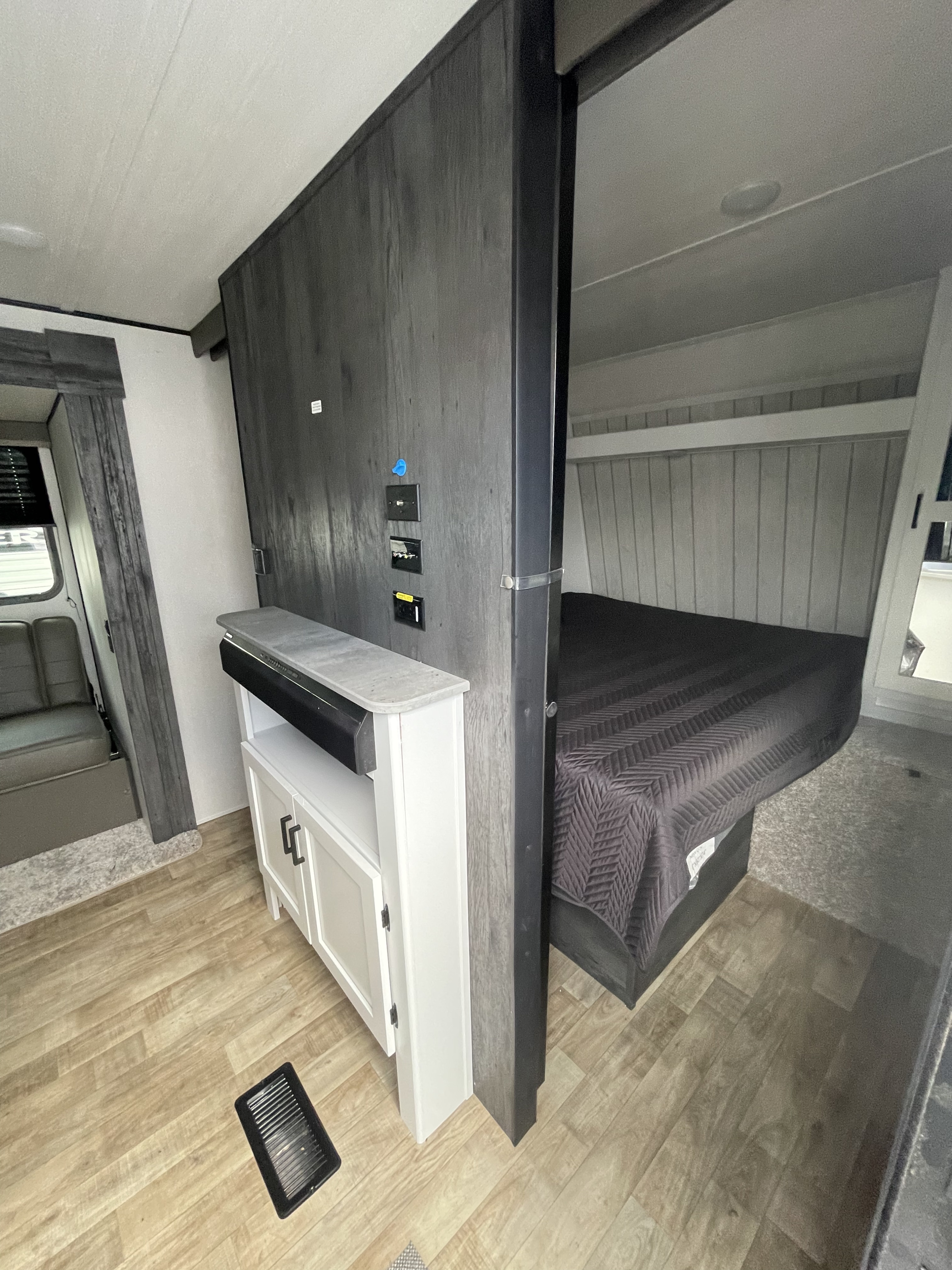 RV rental interior: A compact, modern space featuring a bedroom, living area, and central entertainment console.. Keystone RV Hideout 2022