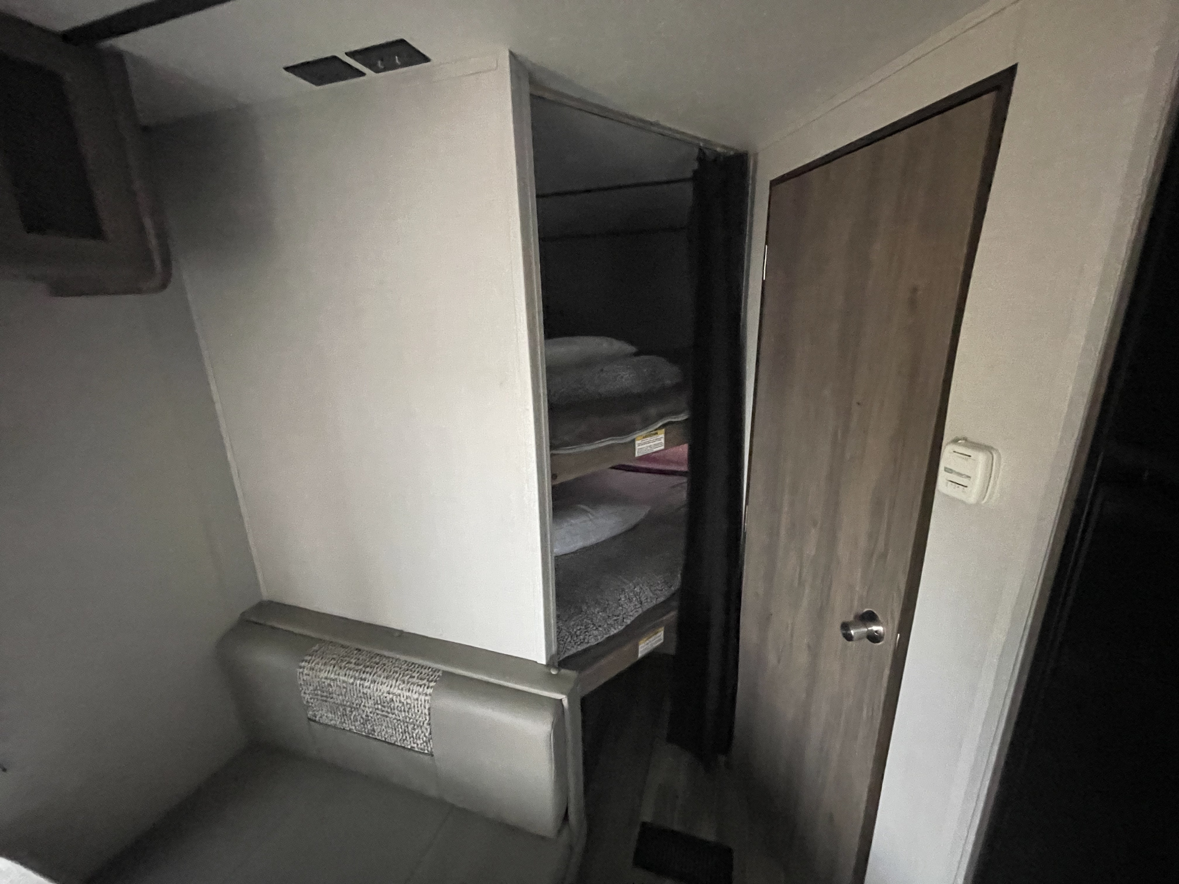 Cozy RV rental interior featuring bunk beds and a compact dinette, ideal for your next family adventure.. Crossroads RV Zinger Lite 2020