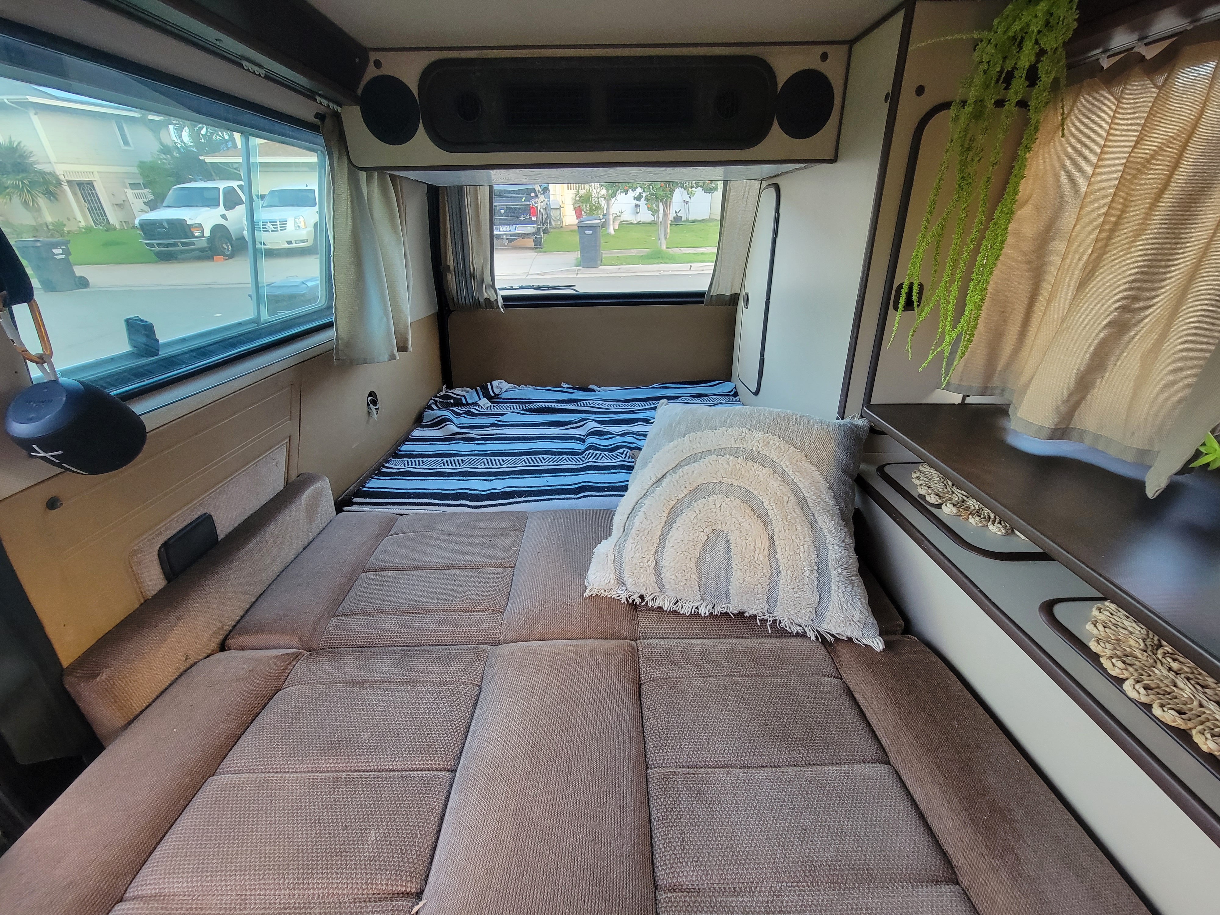 Cozy RV rental interior showcasing a bed setup with a view outside. Ideal for camping and travel adventures.. Volkswagen T2 Westfalia 1985