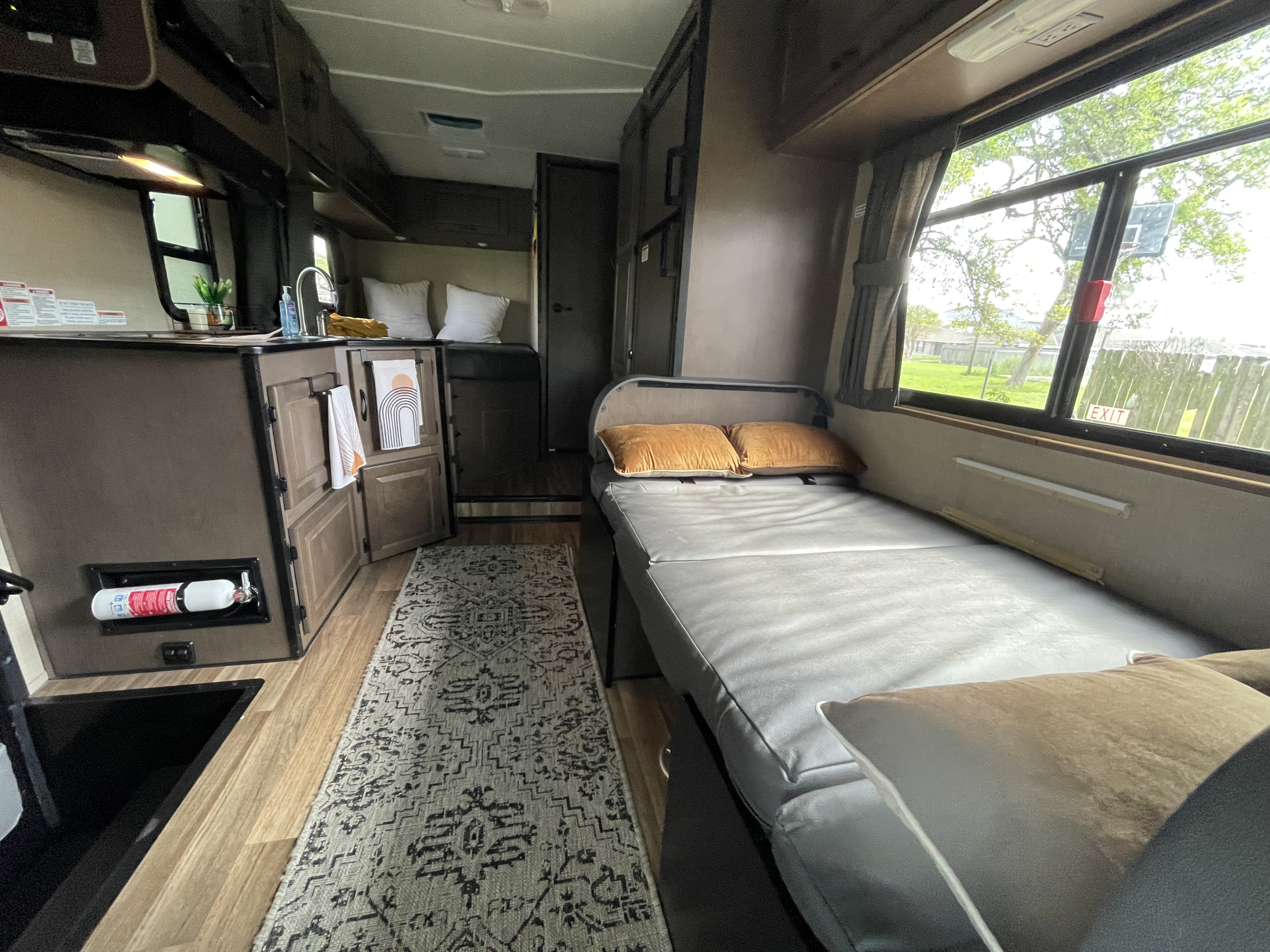 This RV rental interior showcases a cozy living space, including a compact kitchen and convertible bed, perfect for travel.. Wayfarer Wayfarer Motorhome 2020