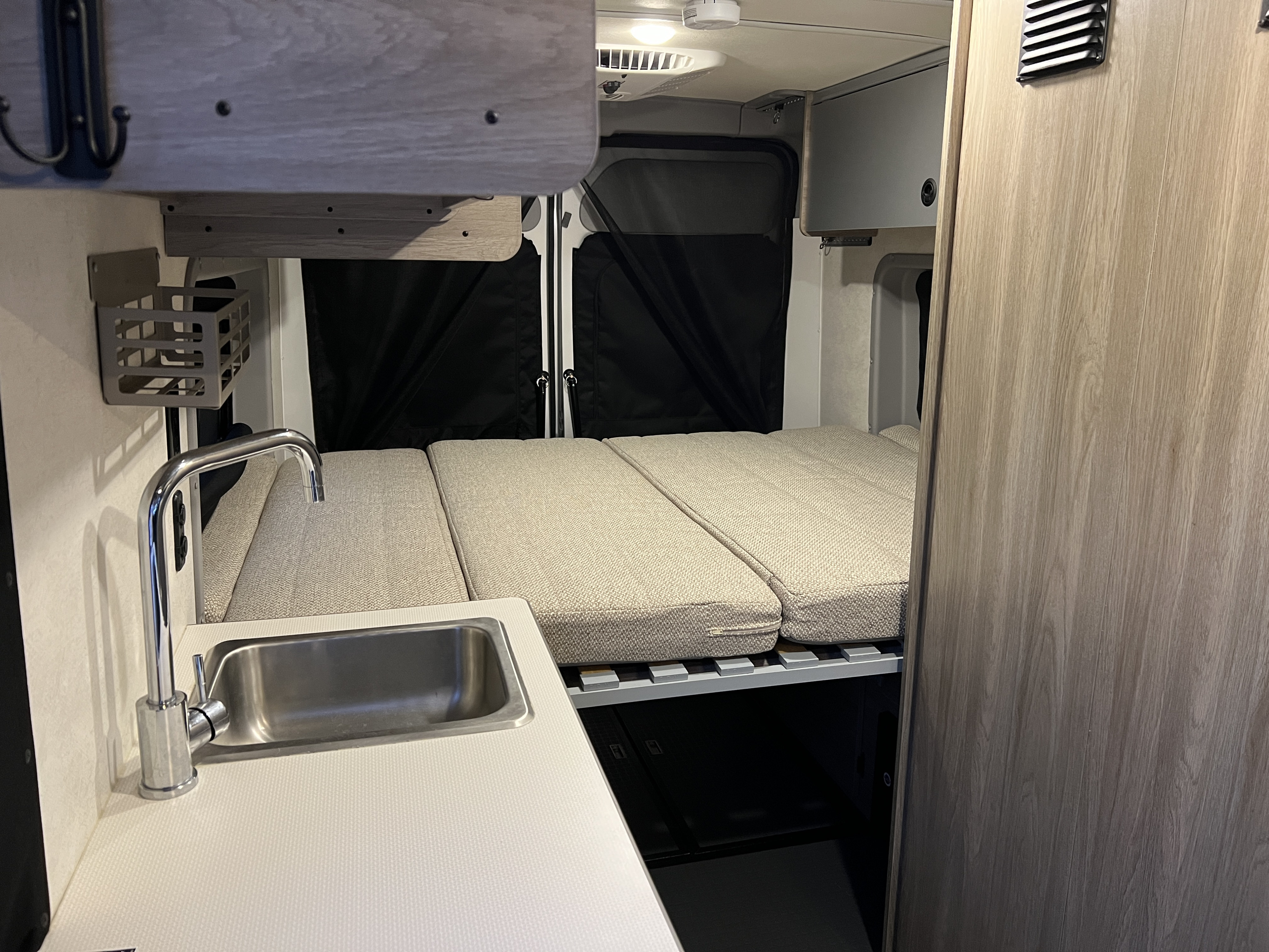 Cozy RV rental interior with kitchenette, bed, and storage. Perfect for adventures.. Winnebago Solis 2022