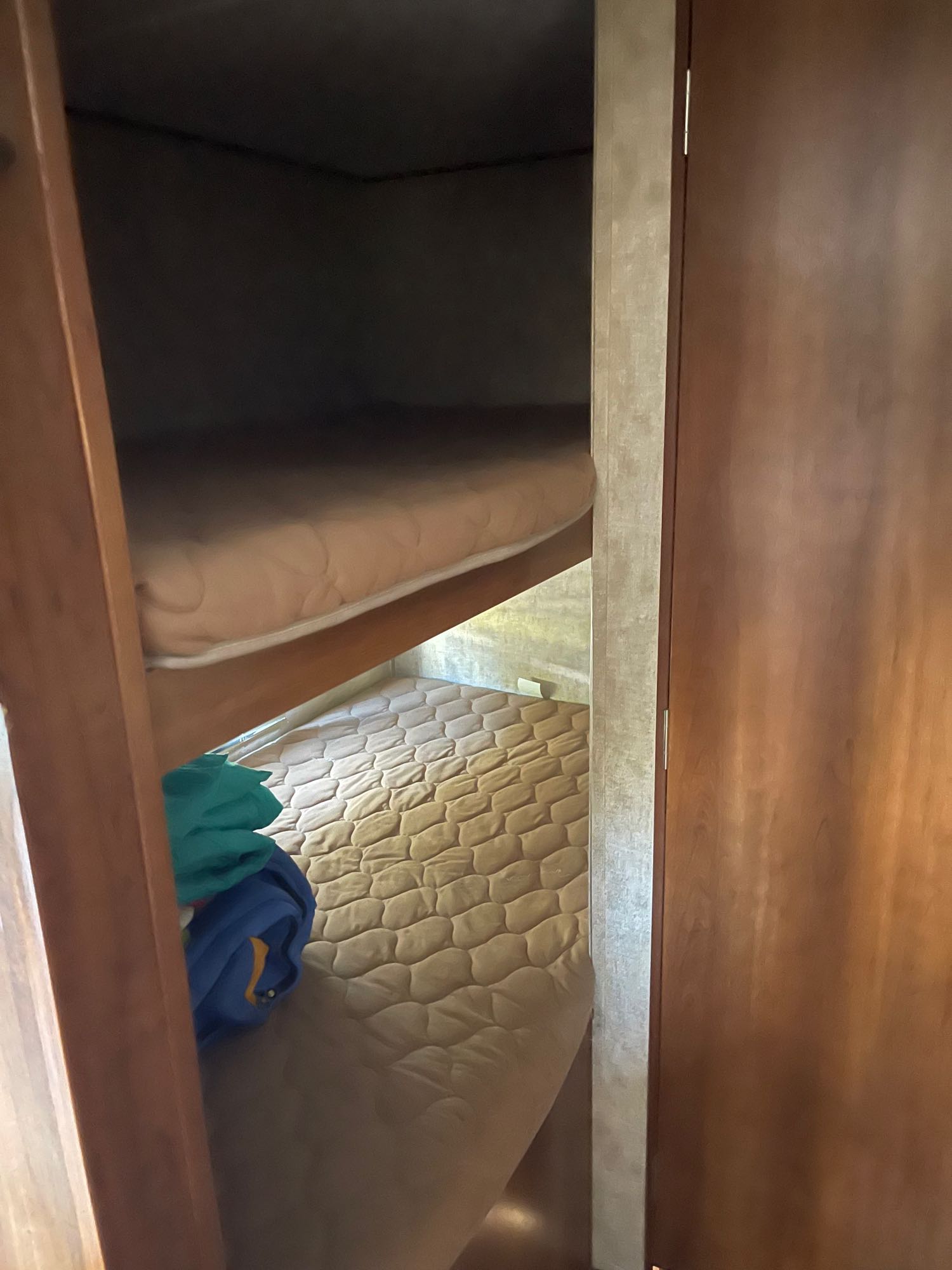 Inside an RV rental: two bunk beds with mattresses, offering compact sleeping space for travelers.. Avenger Avenger Trailer 2015