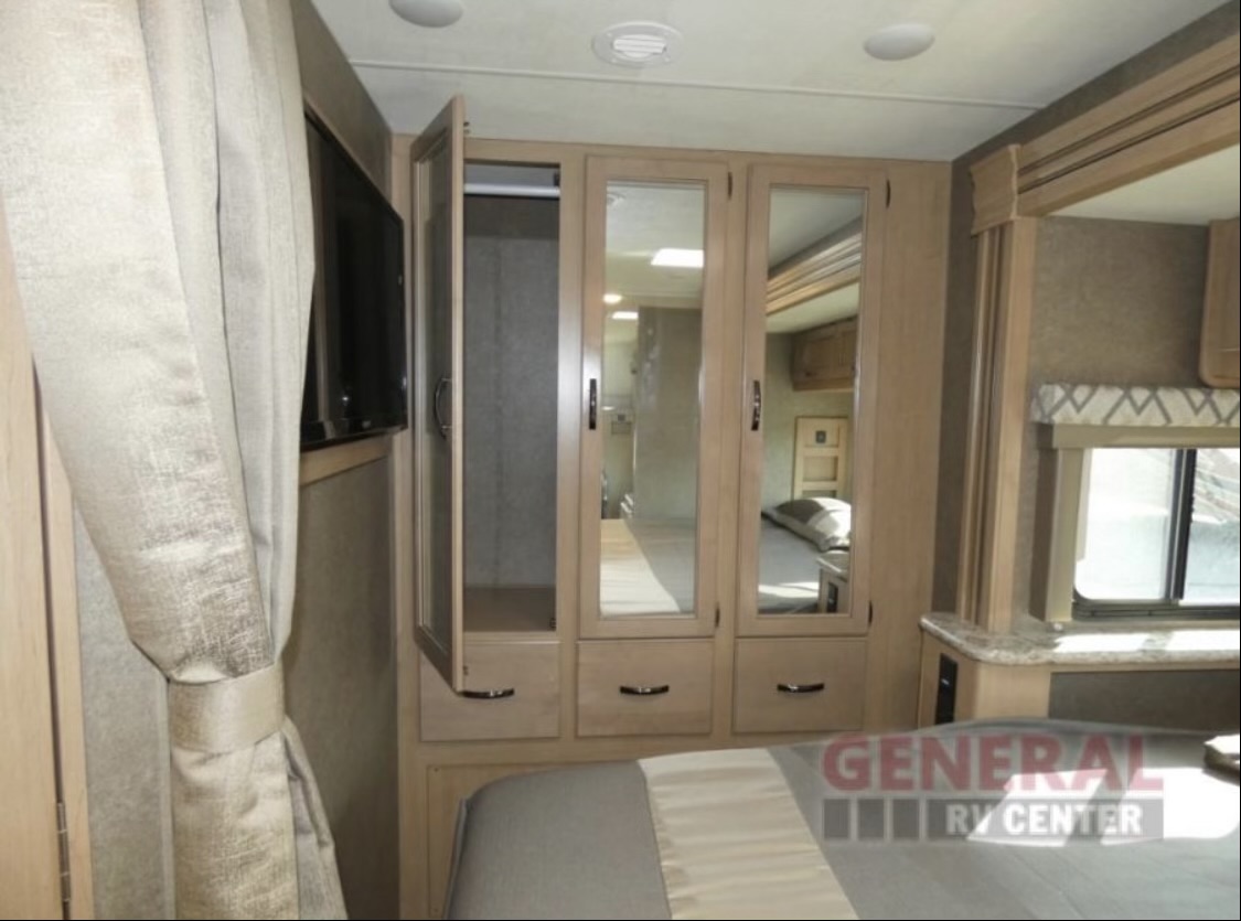 RV rental bedroom: features a comfortable bed, light wood mirrored wardrobe, and wall-mounted TV.. Thor Quantum 2020