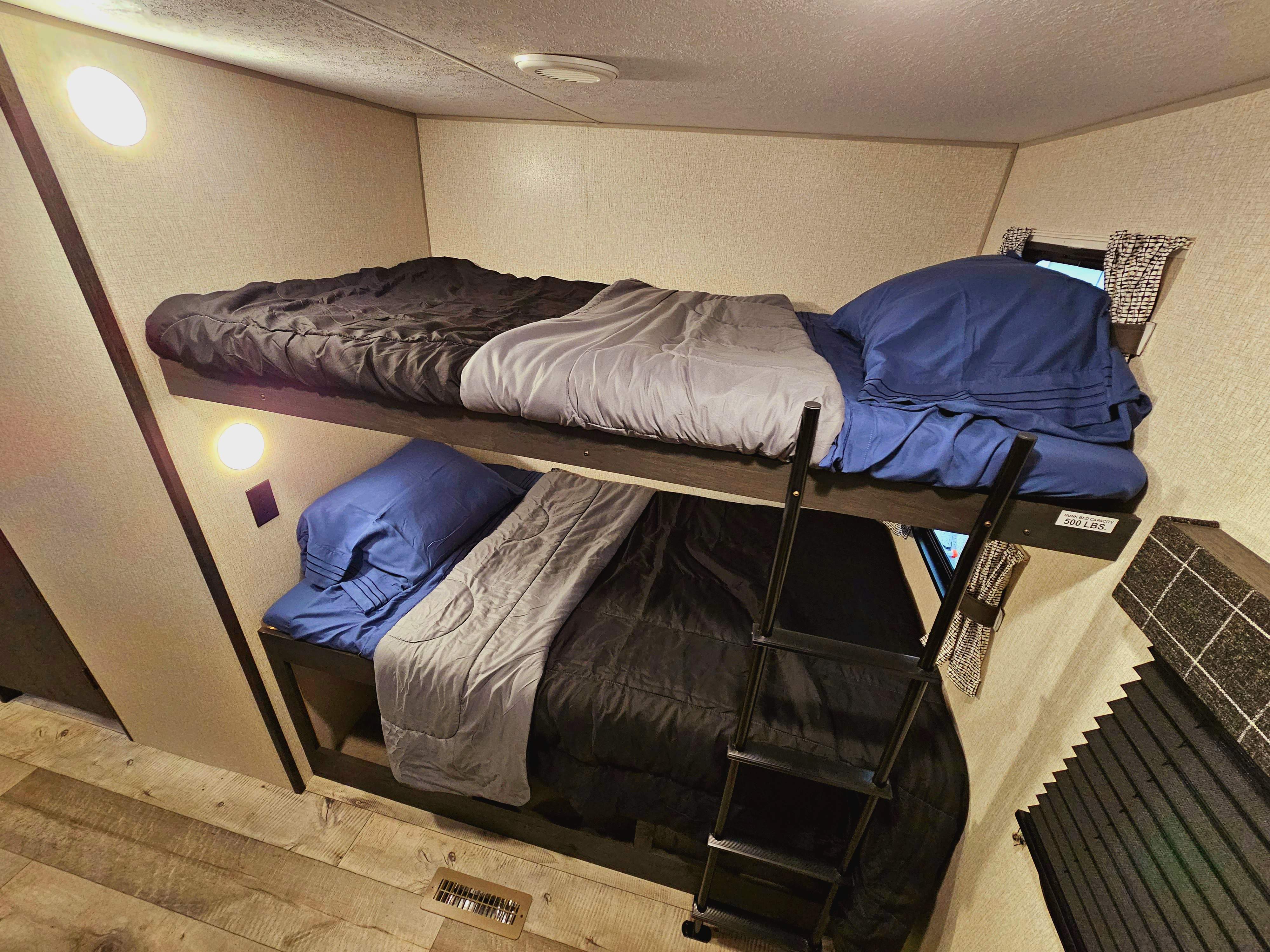 Cozy bunk beds in an RV rental, featuring two neatly made beds with a ladder. Ideal for family adventures.. KZ 312 Bunk House 2022