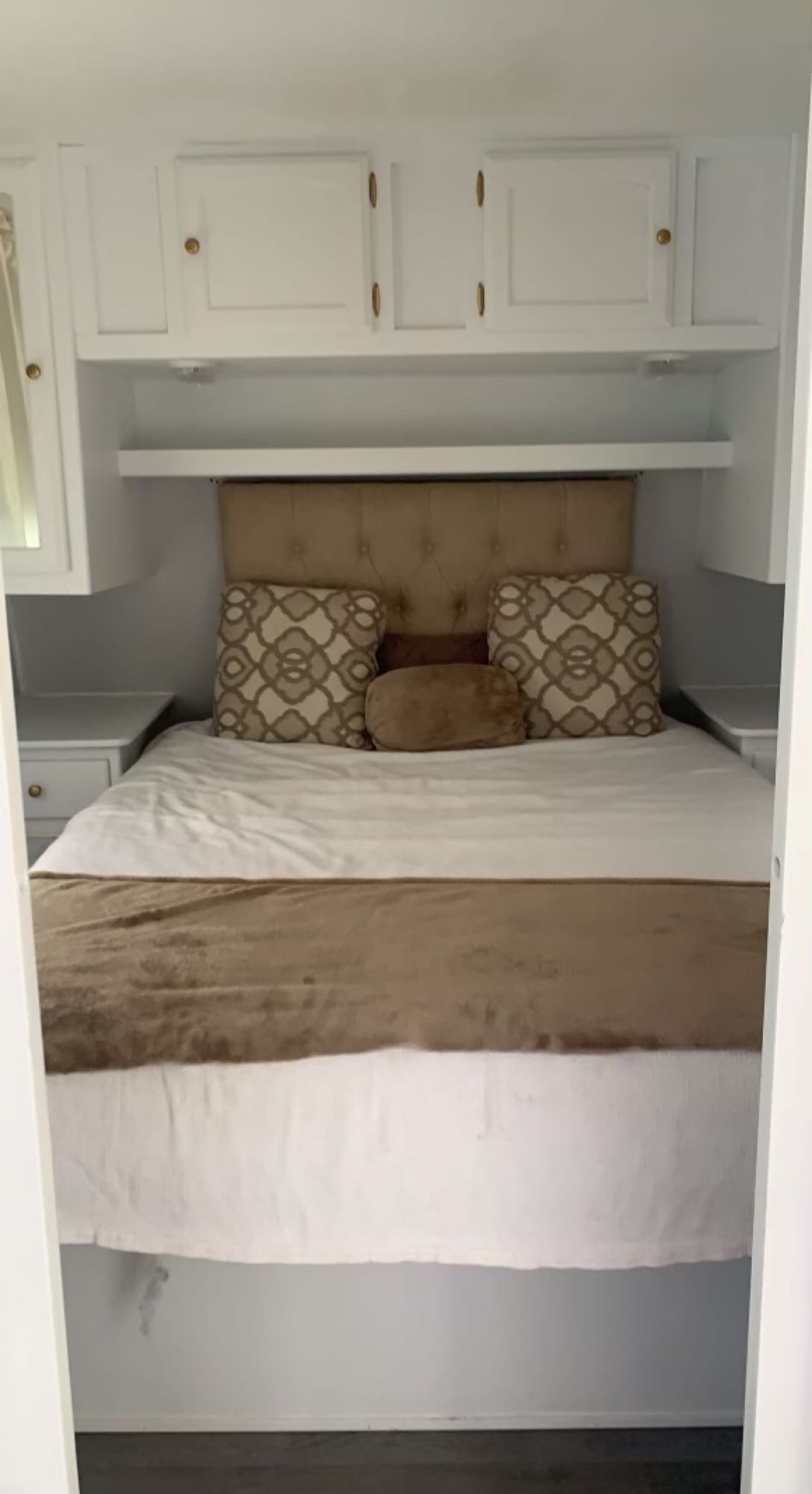 Serene RV rental bedroom features a comfy queen bed with neutral linens, sleek white cabinetry, and practical shelving.. Dutchmen Dutchmen 2009