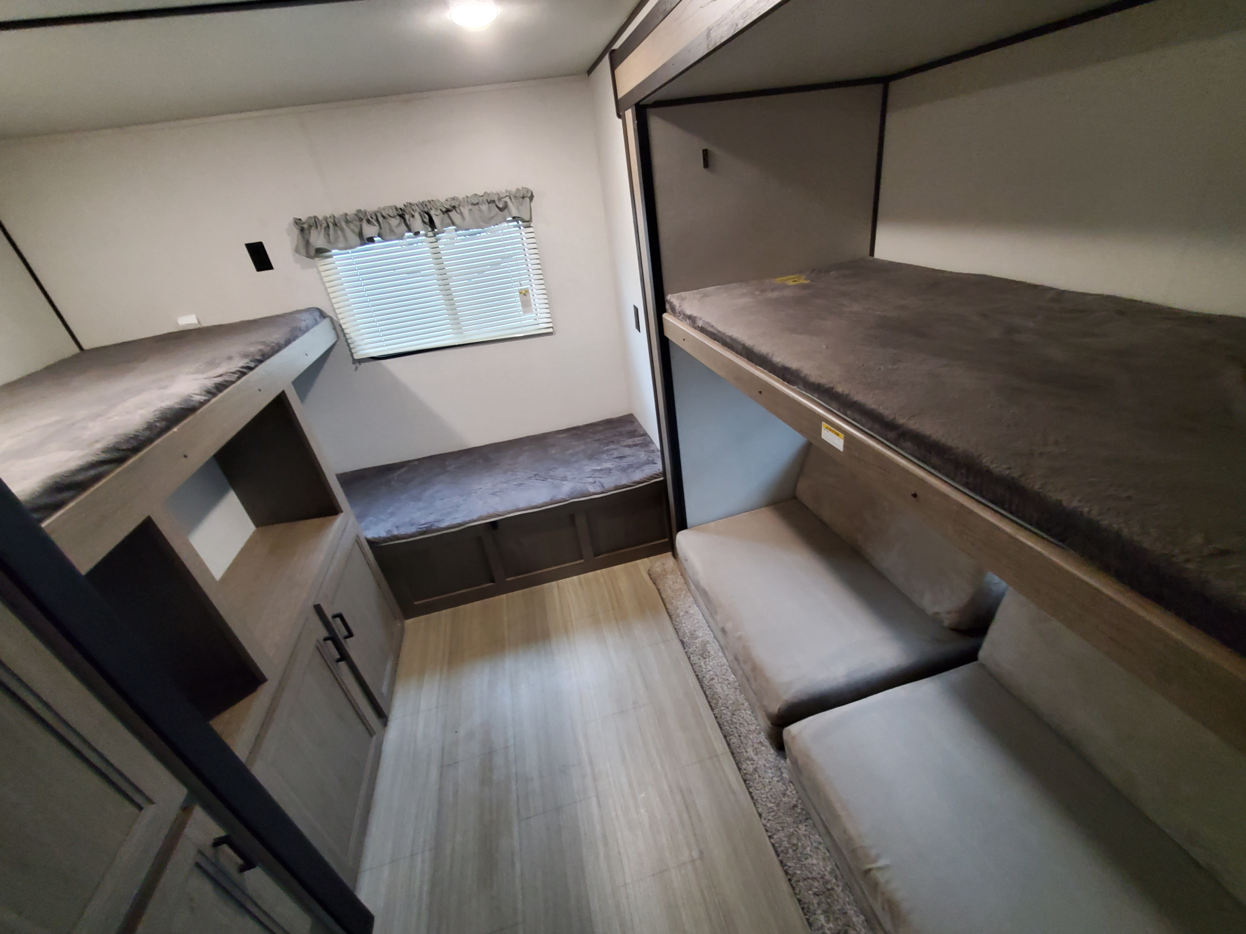 RV rental: Modern interior with bunk beds, under-bunk storage, and cushioned bench seating for guests.. Keystone Hideout 2020