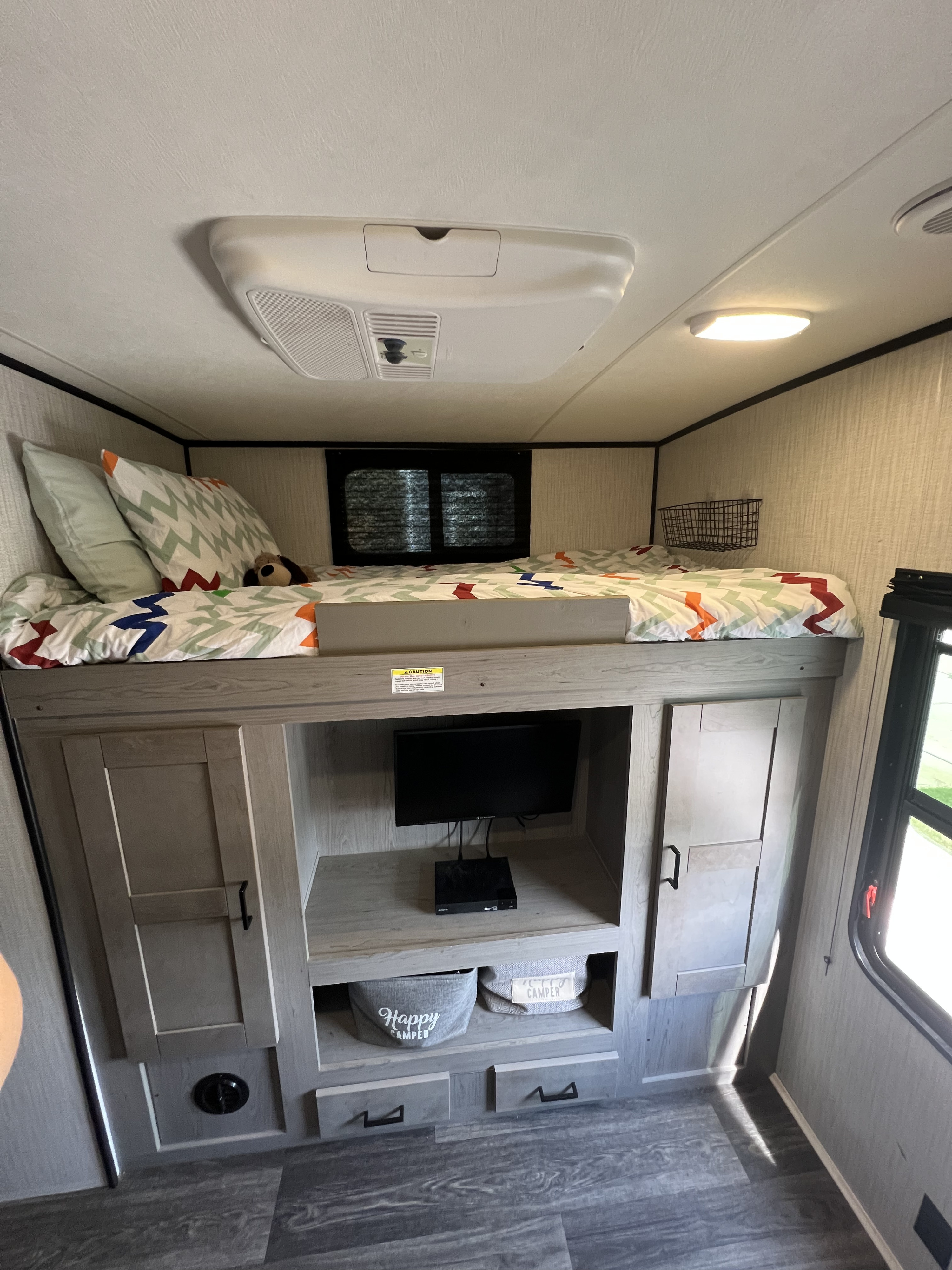 RV rental bunk room showing a made bed, TV console, and storage, ideal for kids or extra guests.. Heartland RVs Mallard 2021