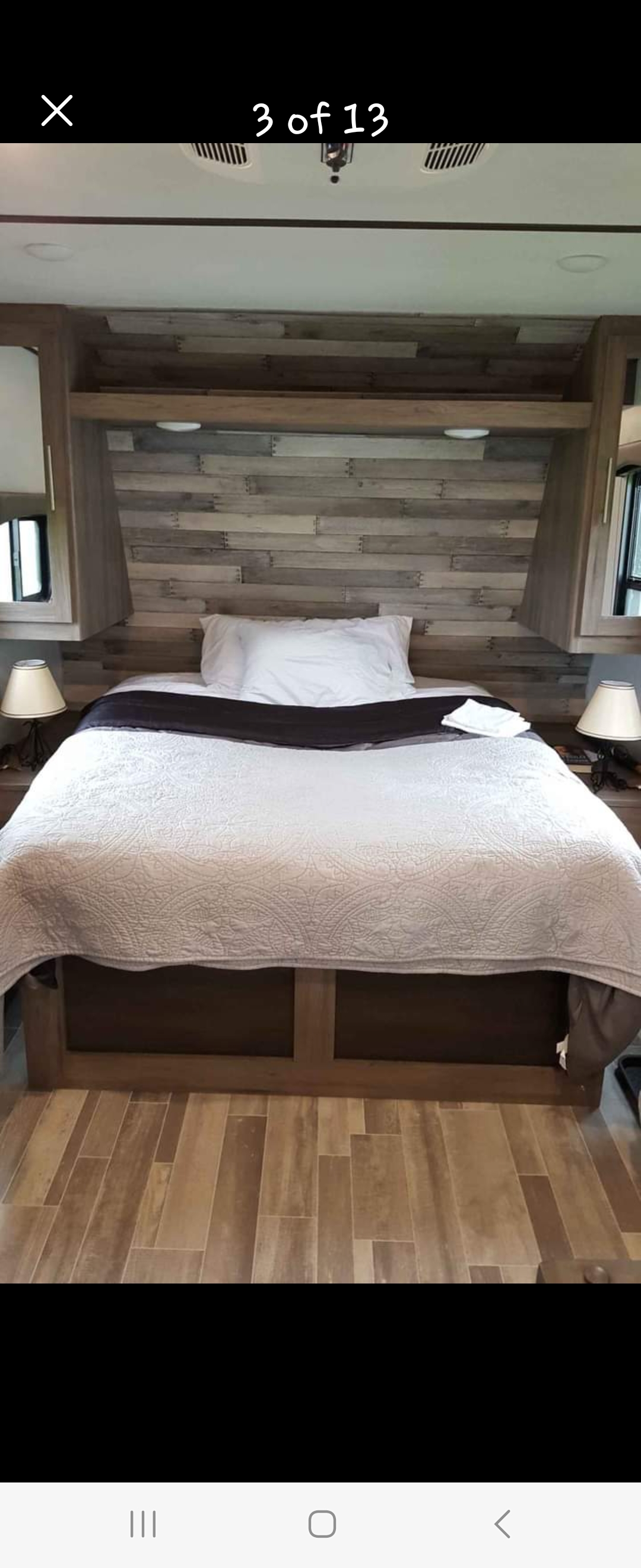 Cozy RV rental bedroom featuring a queen bed with white bedding, wood-paneled headboard, and built-in storage.. Crossroads RV Zinger Lite 2020