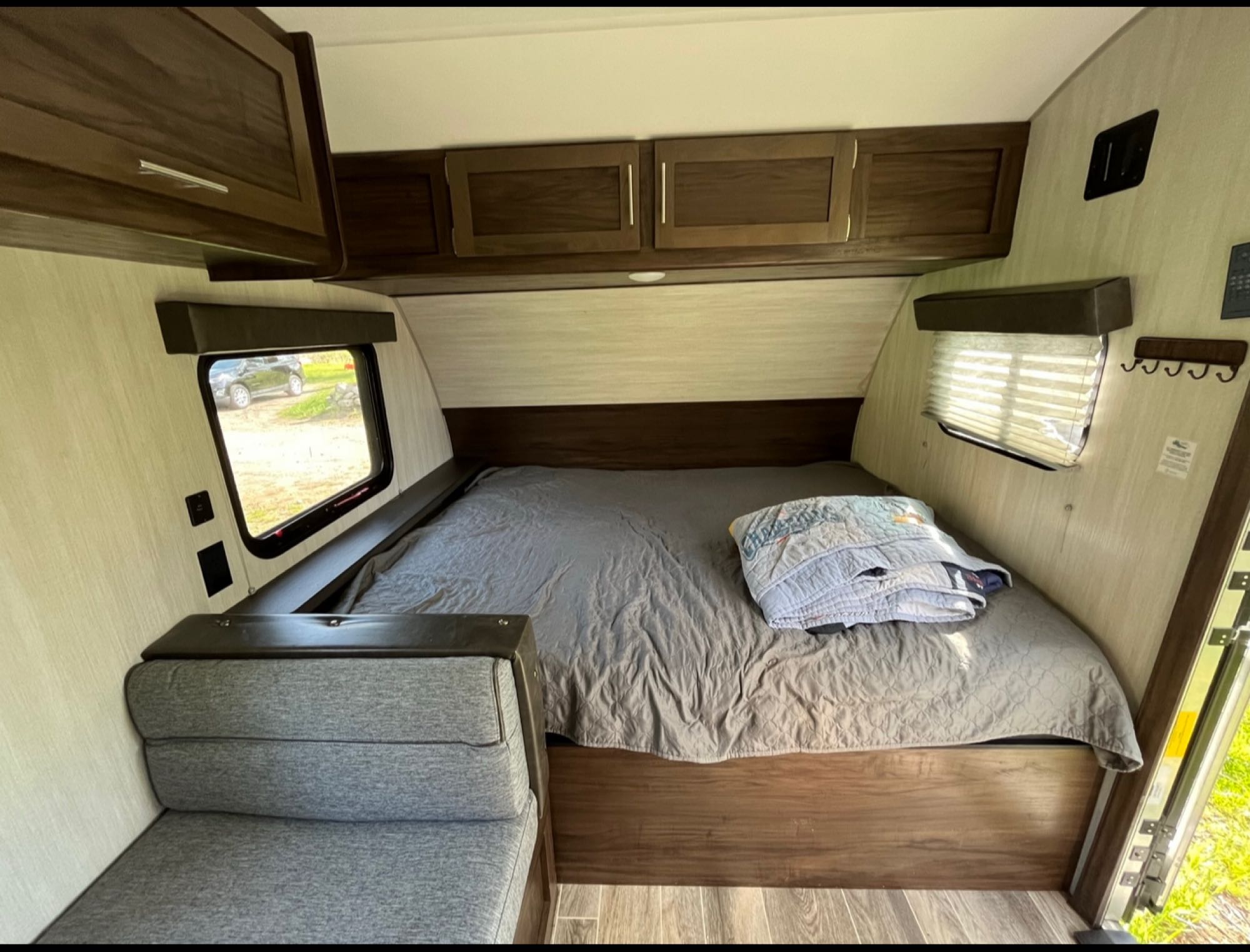 RV rental bedroom: a comfy bed, overhead storage, and seating area for cozy road trips.. Forest River Cherokee Wolf Pup 2019