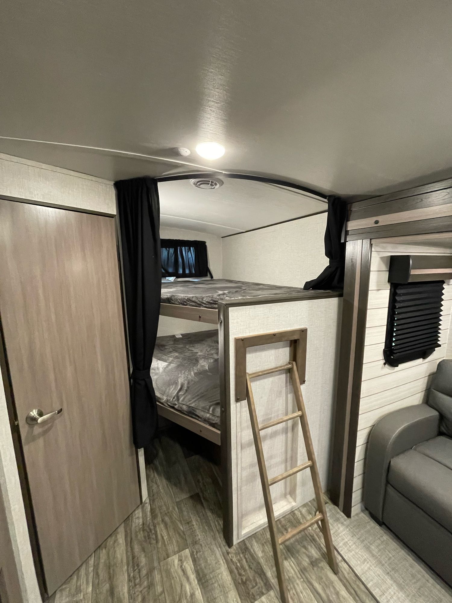 Cozy RV rental interior with bunk beds, privacy curtains, and ladder. Perfect for family camping adventures.. Crossroads RV Sunset Trail Super Lite 2022