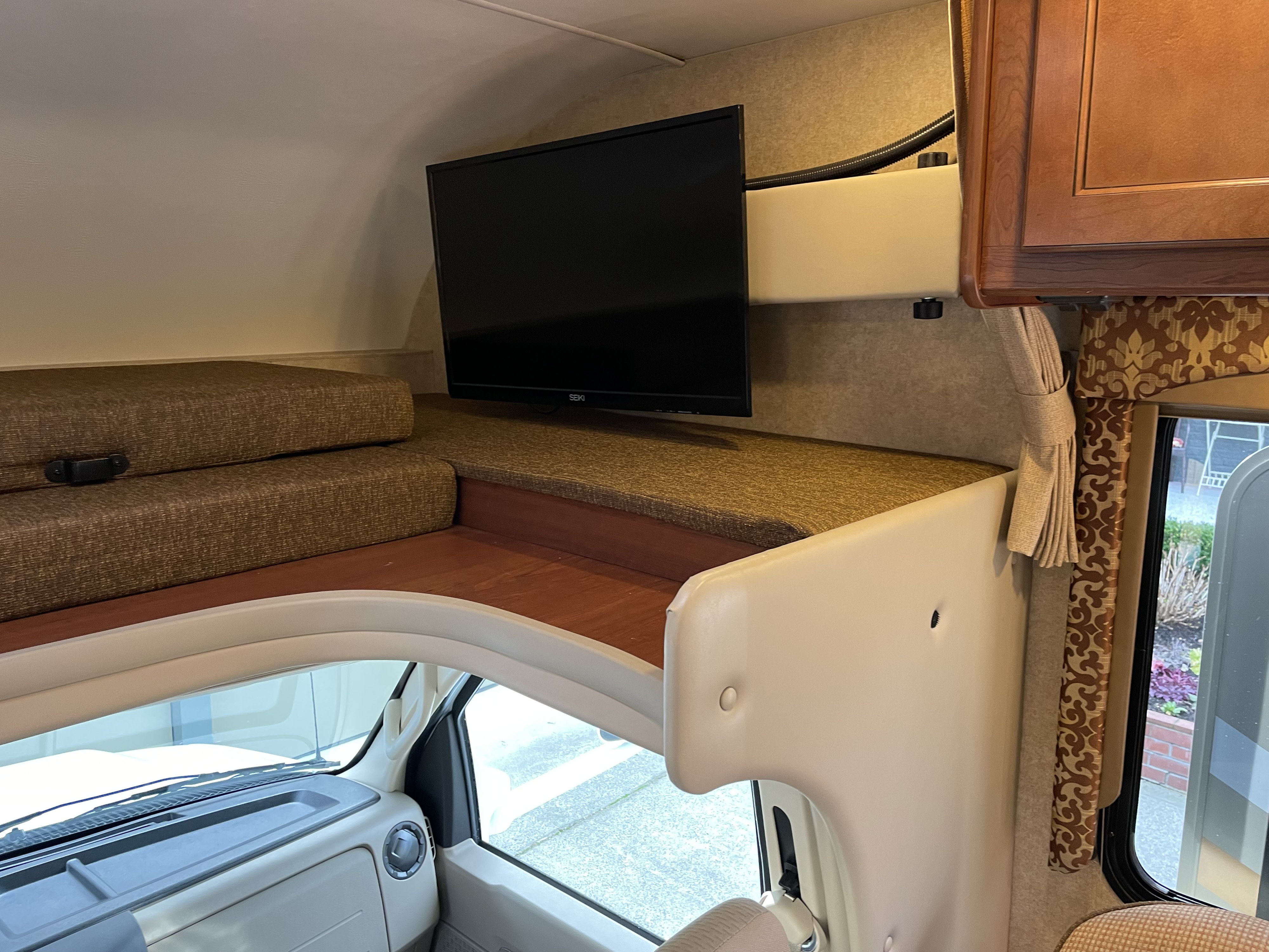 RV rental's spacious cab-over bunk features a TV & cozy sleeping space above the cockpit.. Thor Freedom Elite 2017