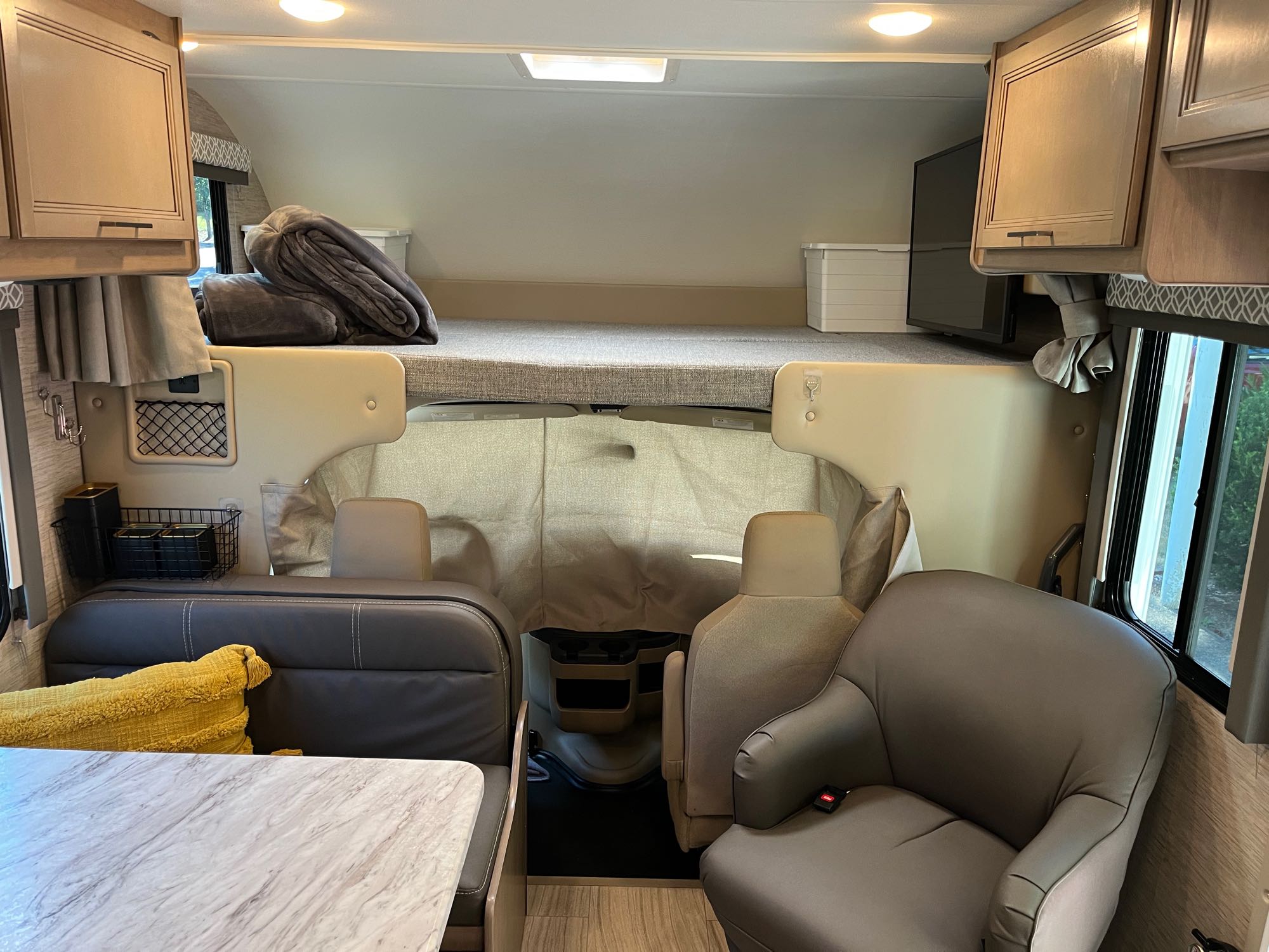 Step inside this RV rental: an overhead bed, dining area with table, and comfortable driver/passenger seats.. Thor Motor Coach Other 2022
