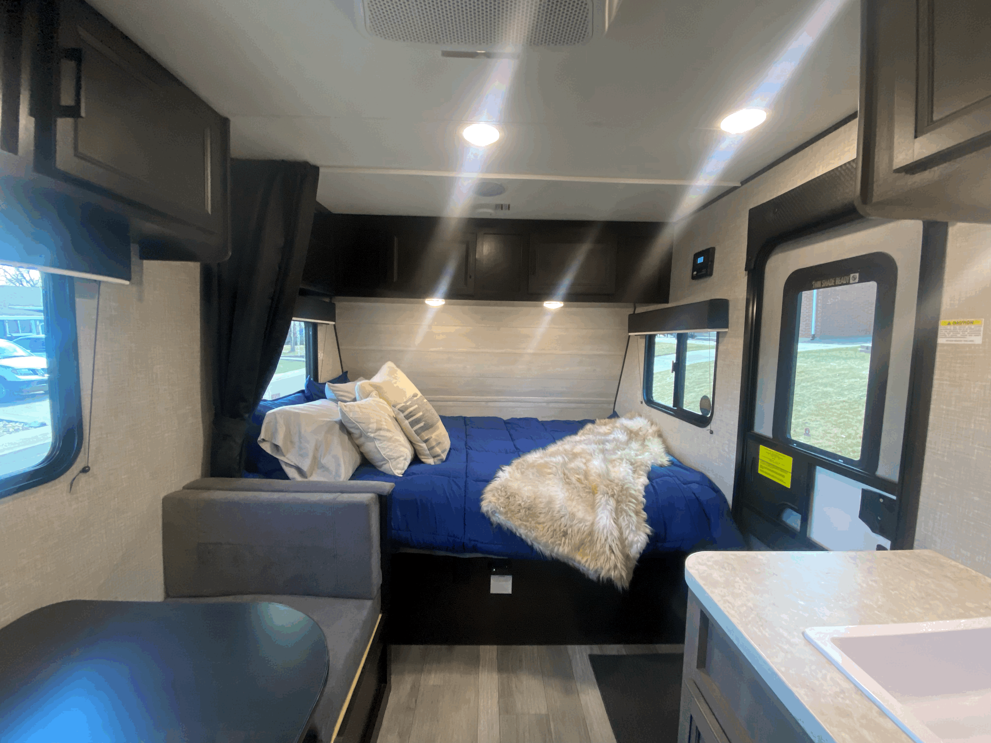 Cozy RV rental bedroom and living area, featuring a comfortable bed, dinette, and sink. Ideal for travel trailer adventures.. Jayco Jay Flight 2022