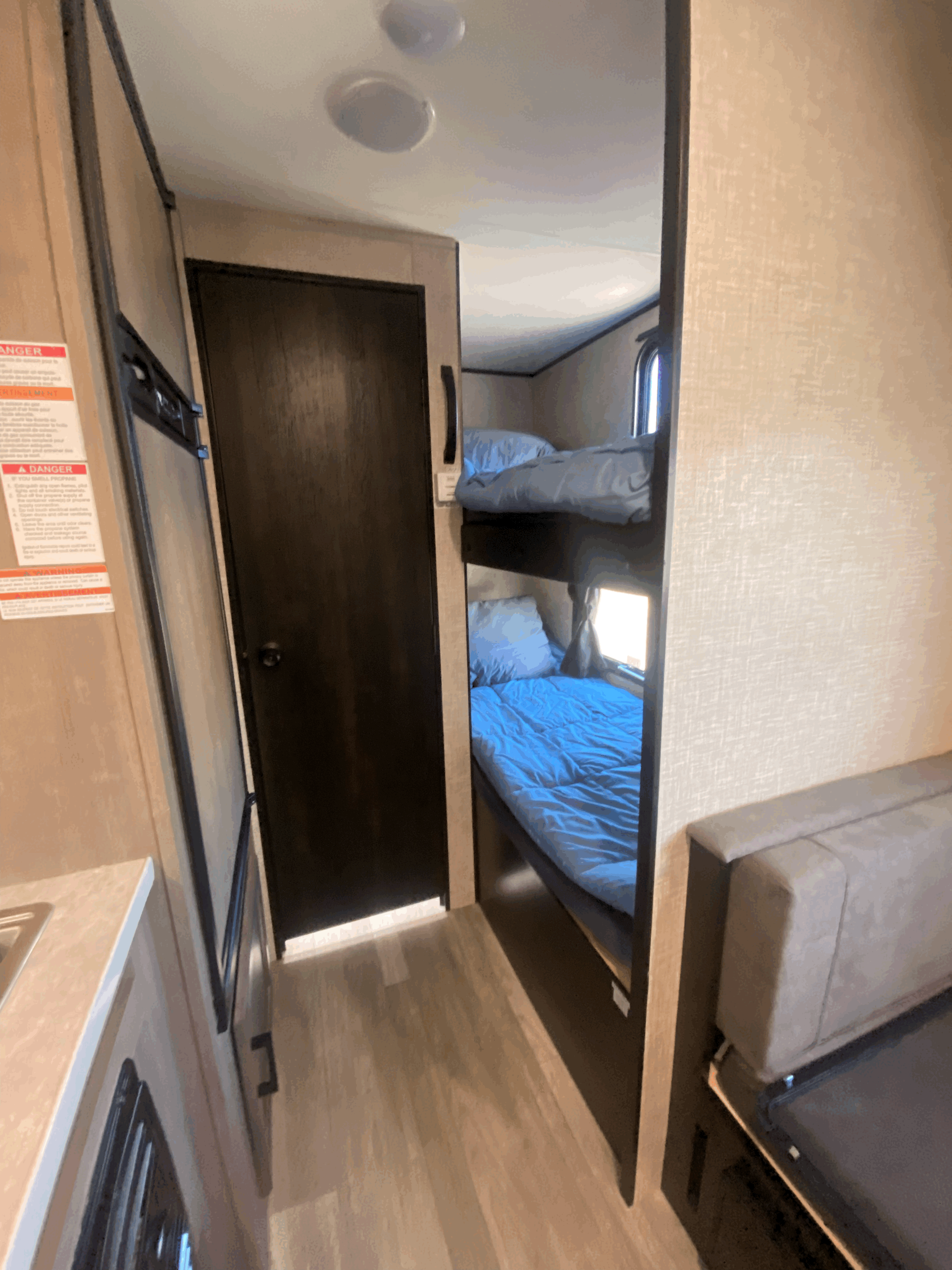 Explore this rv rental's interior featuring comfortable bunk beds, a compact kitchen, and a cozy seating area.. Jayco Jay Flight 2022