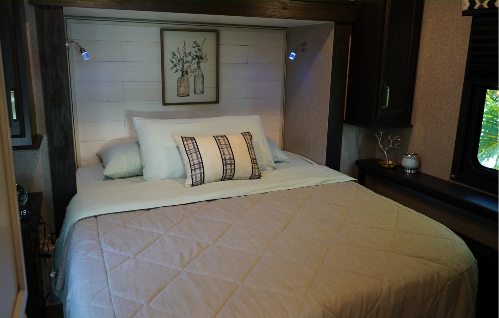Inviting RV rental bedroom with a comfortable bed, shiplap headboard, and bedside lighting.. Entegra Coach Odyssey 2021