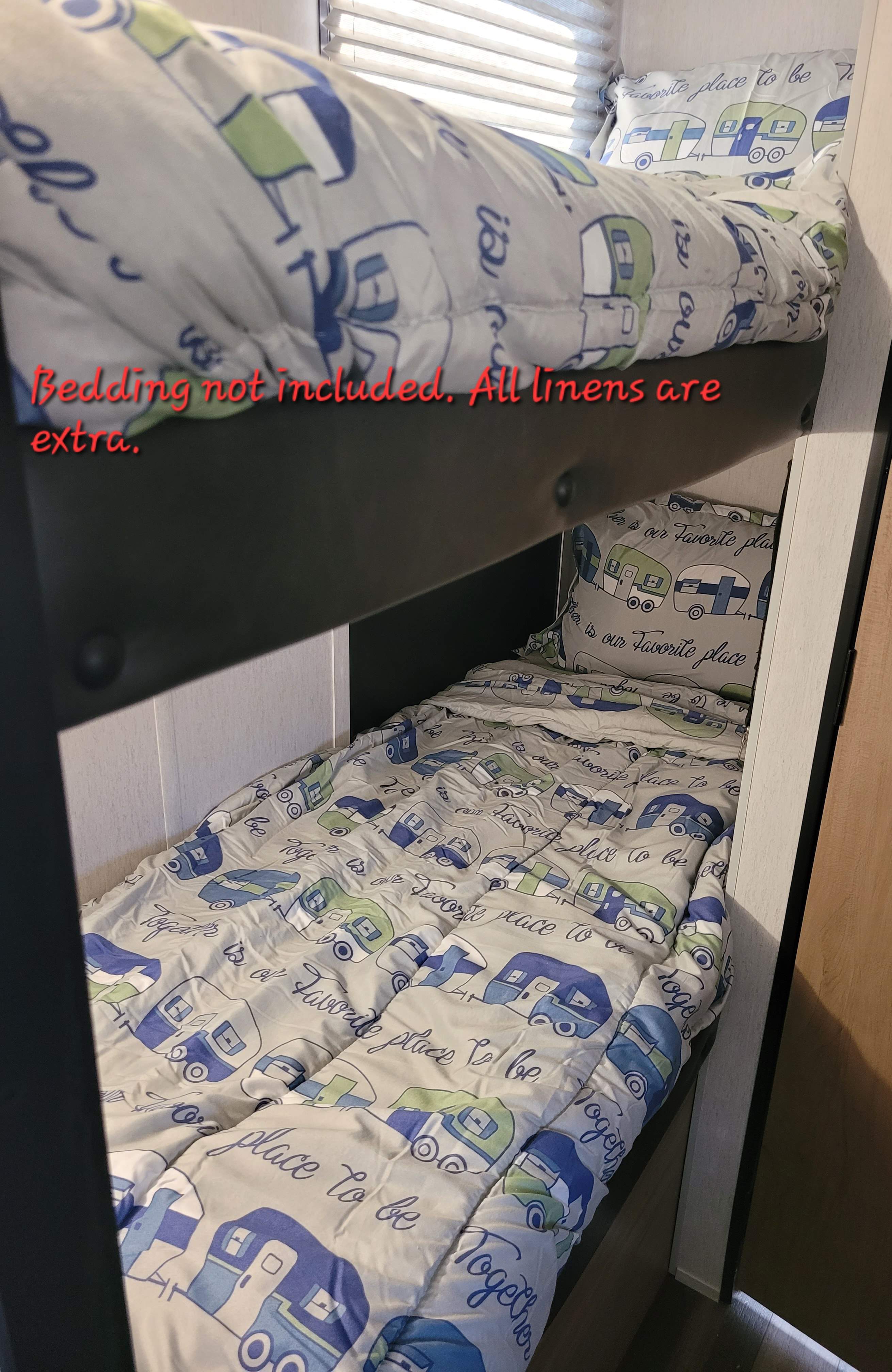 View inside an **RV rental**: cozy bunk beds with **camper-themed bedding**. Please note: **linens extra** for your stay.. forest river wolf pup 2023