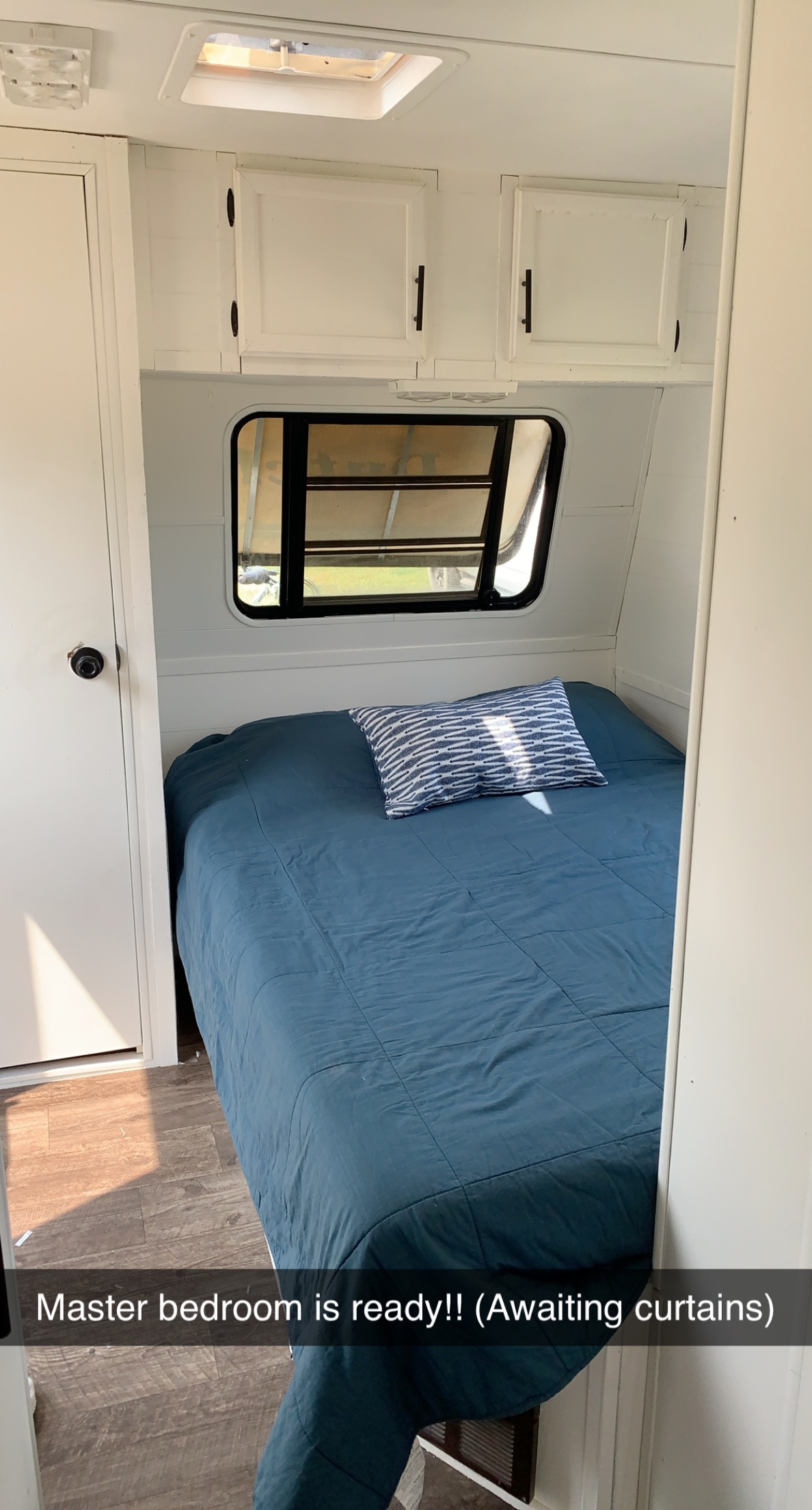 Step inside this RV rental master bedroom featuring a comfy bed with blue bedding, window, & cabinets.. Dutchmen Classic 1993