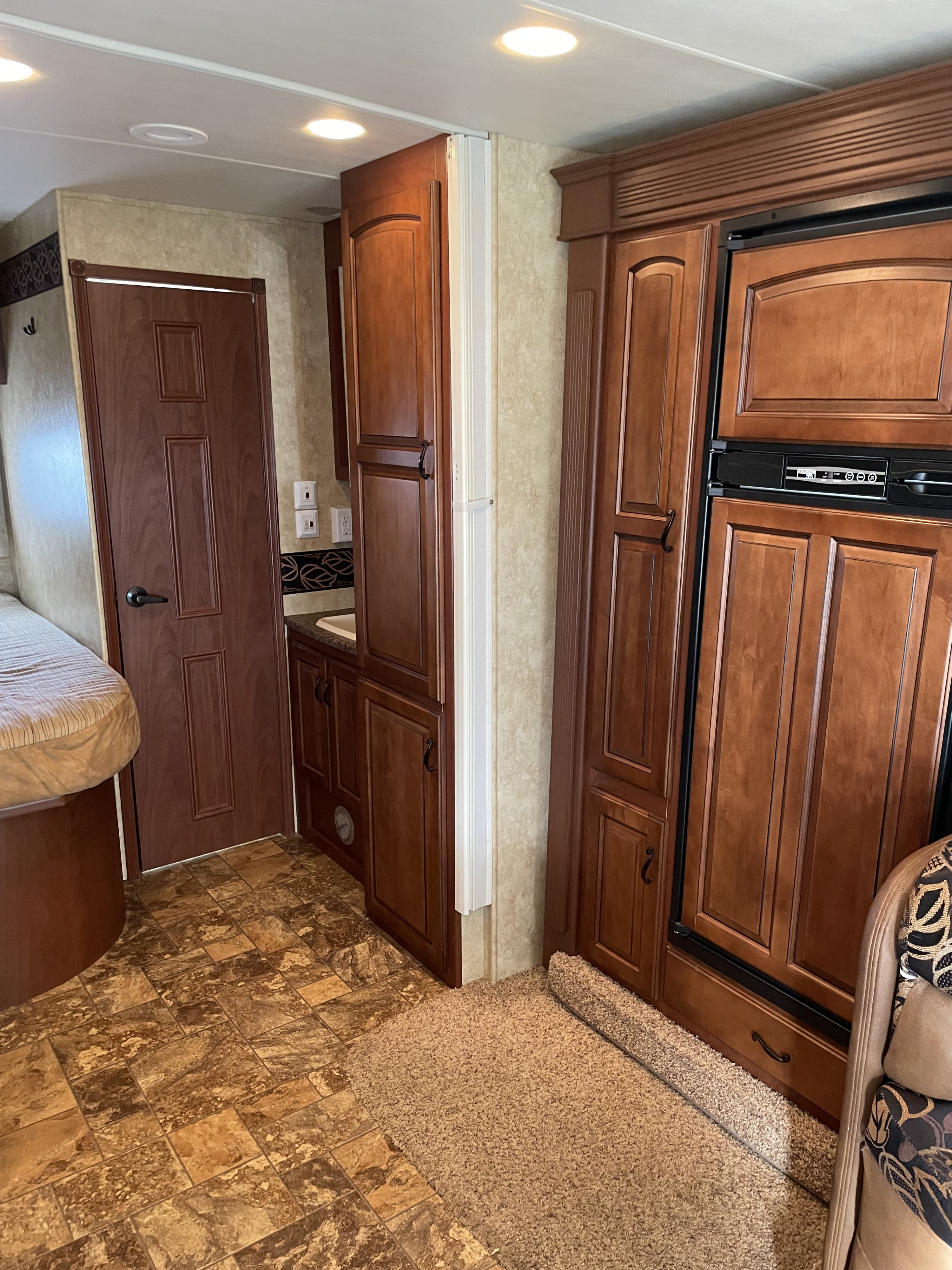 Inside a well-appointed RV rental, showcasing a compact kitchenette, bed area, and built-in storage. Ideal for comfortable travel.. Jayco Greyhawk 2011
