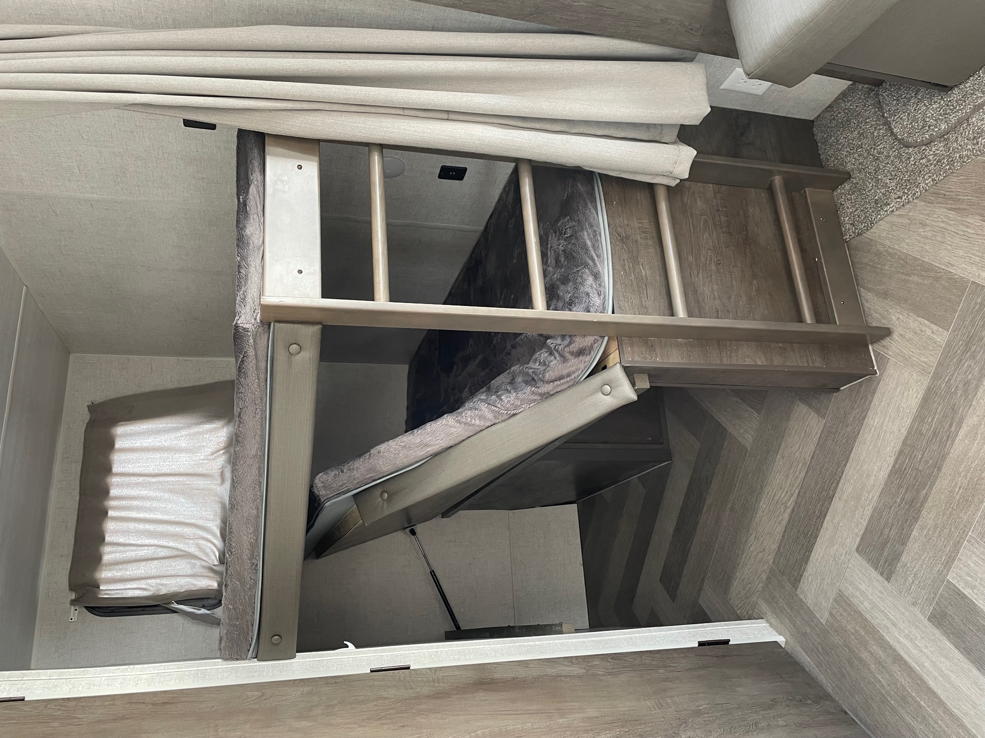 RV rental interior: Bunk beds, one lifted for storage, offer cozy sleeping in this modern RV.. Forest River Wildwood 2021