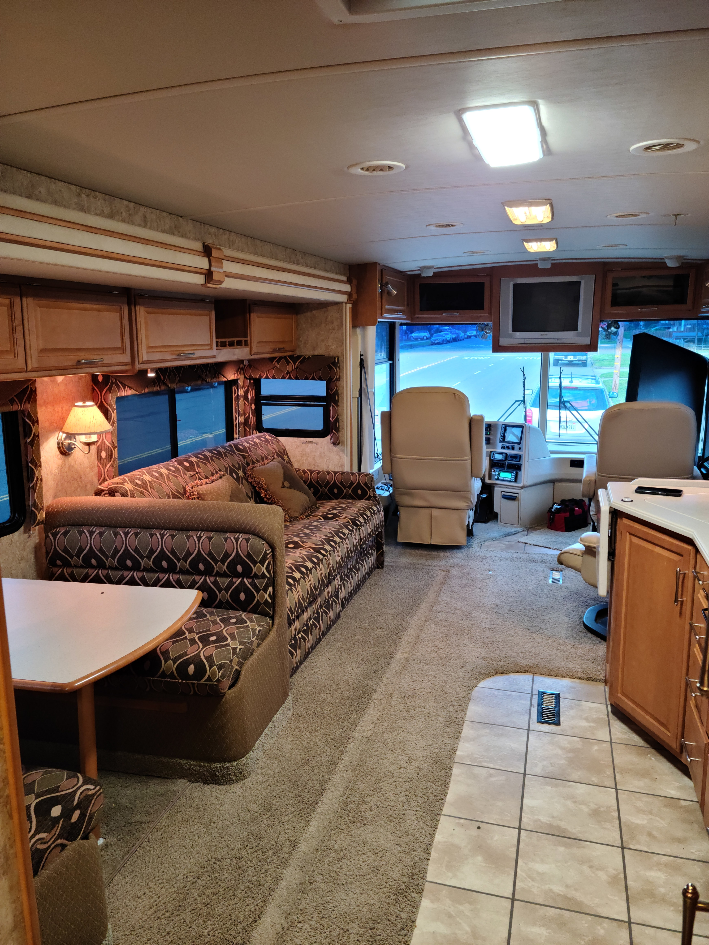 RV rental: Interior view of a spacious motorhome living area with sofa, dining booth, and cockpit.. Winnebago Journey 2006