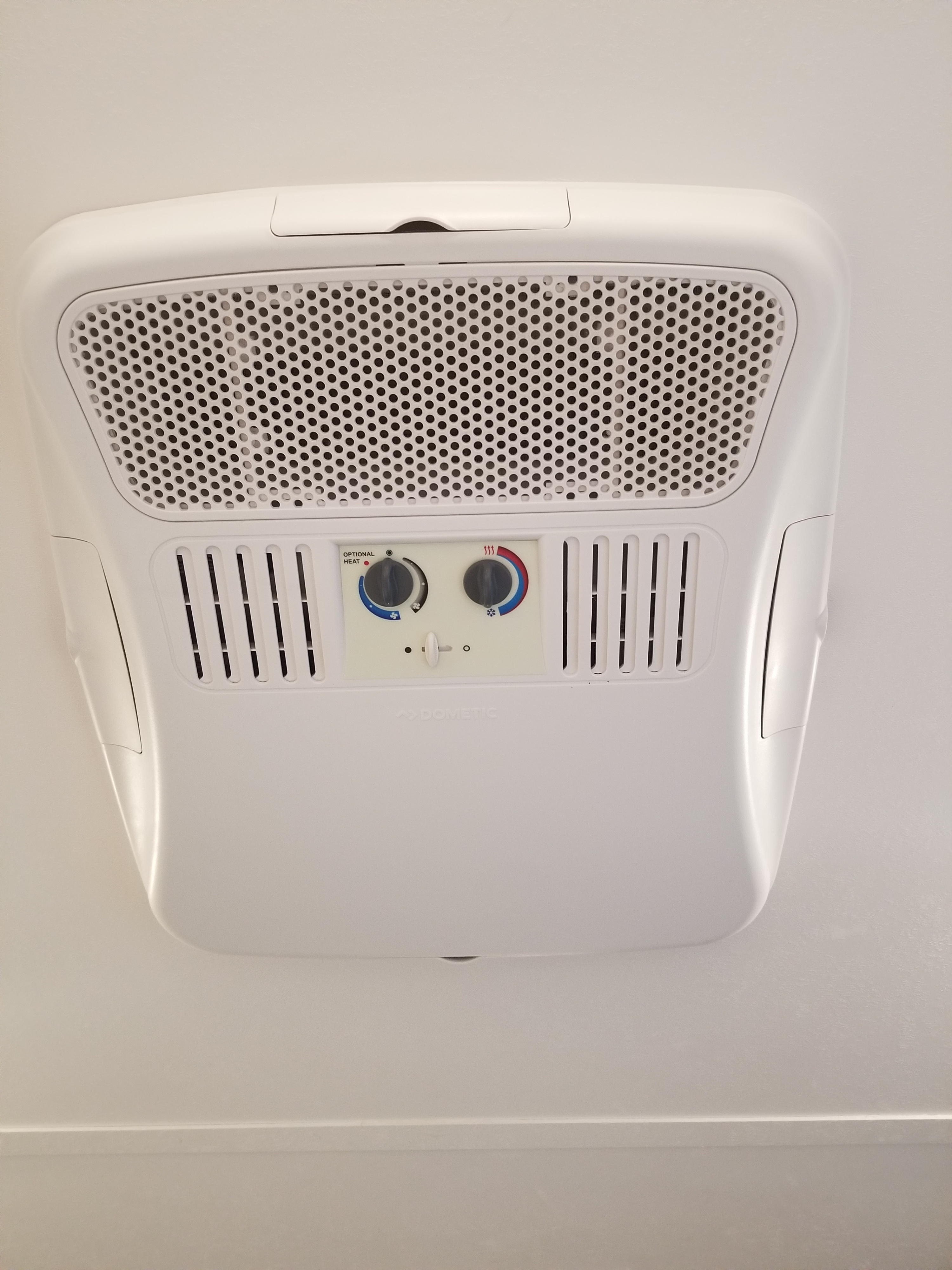 Overhead Dometic RV air conditioner/heater unit, perfect for RV rental comfort. Features cooling, heating, and fan controls.. Aspen Trail LE 2022