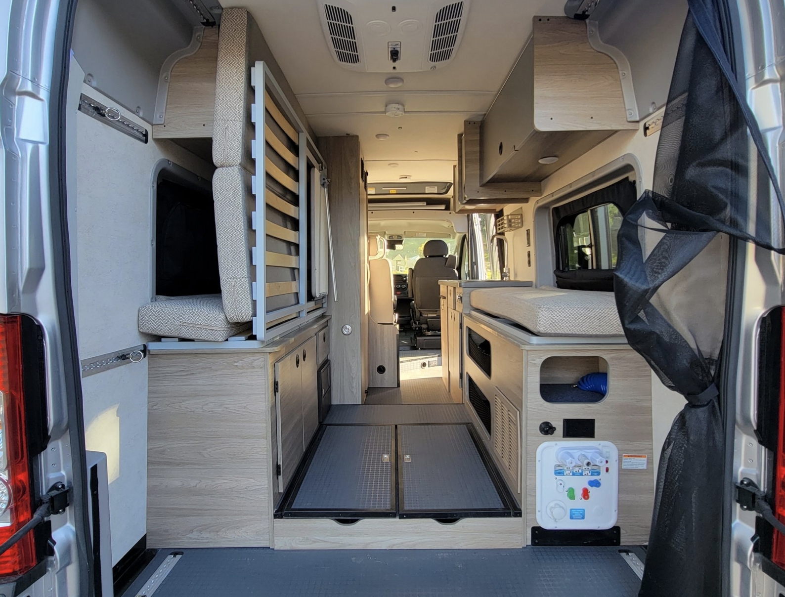 Modern RV rental interior, from rear to front, showcasing modular beds, smart storage, and compact living amenities.. Winnebago Solis 59PX 2021