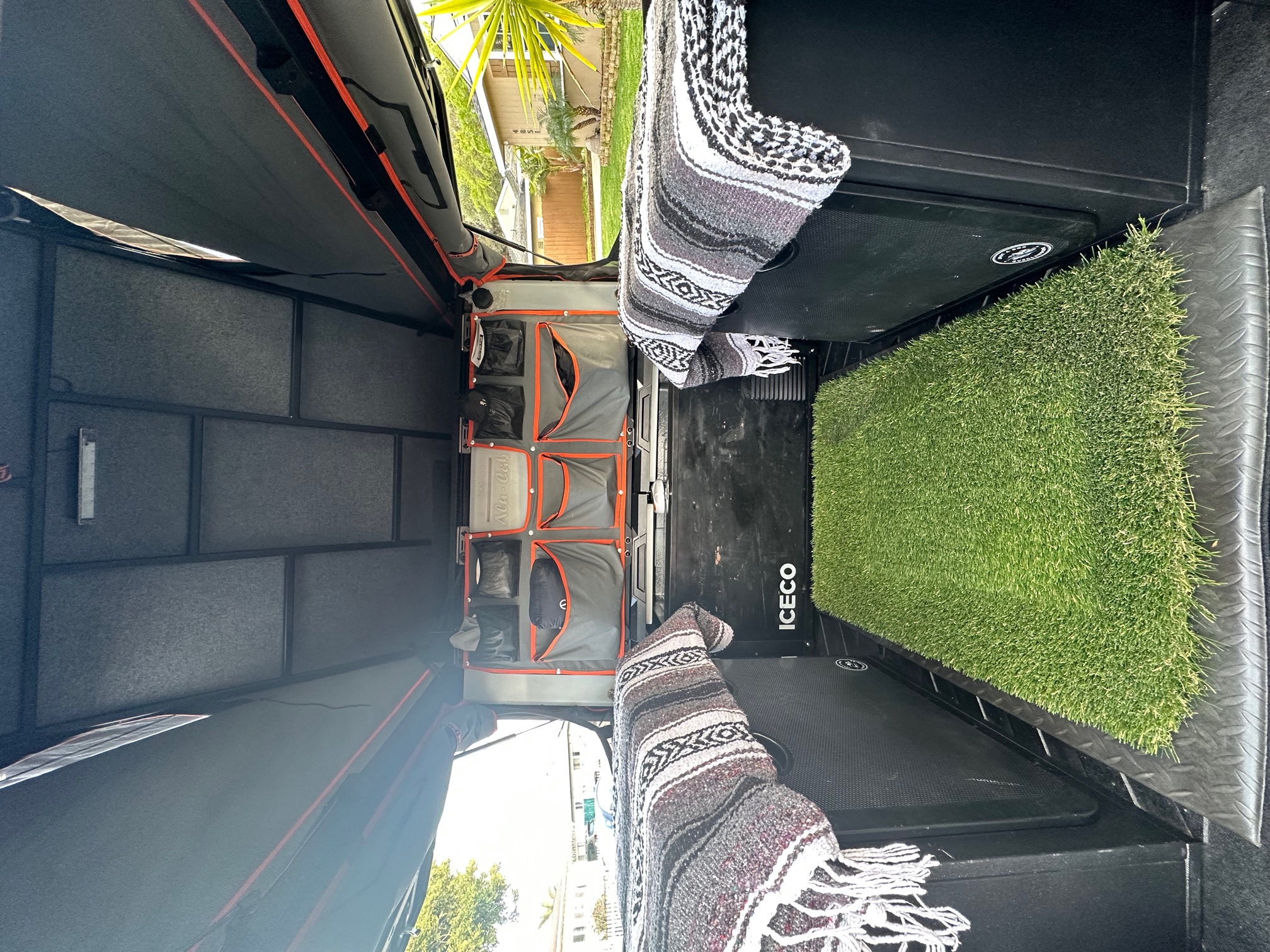 RV rental overland interior: modular storage, ICECO fridge, comfy blankets, & an artificial grass mat.. toyota Tacoma TRD Off-Road 2017
