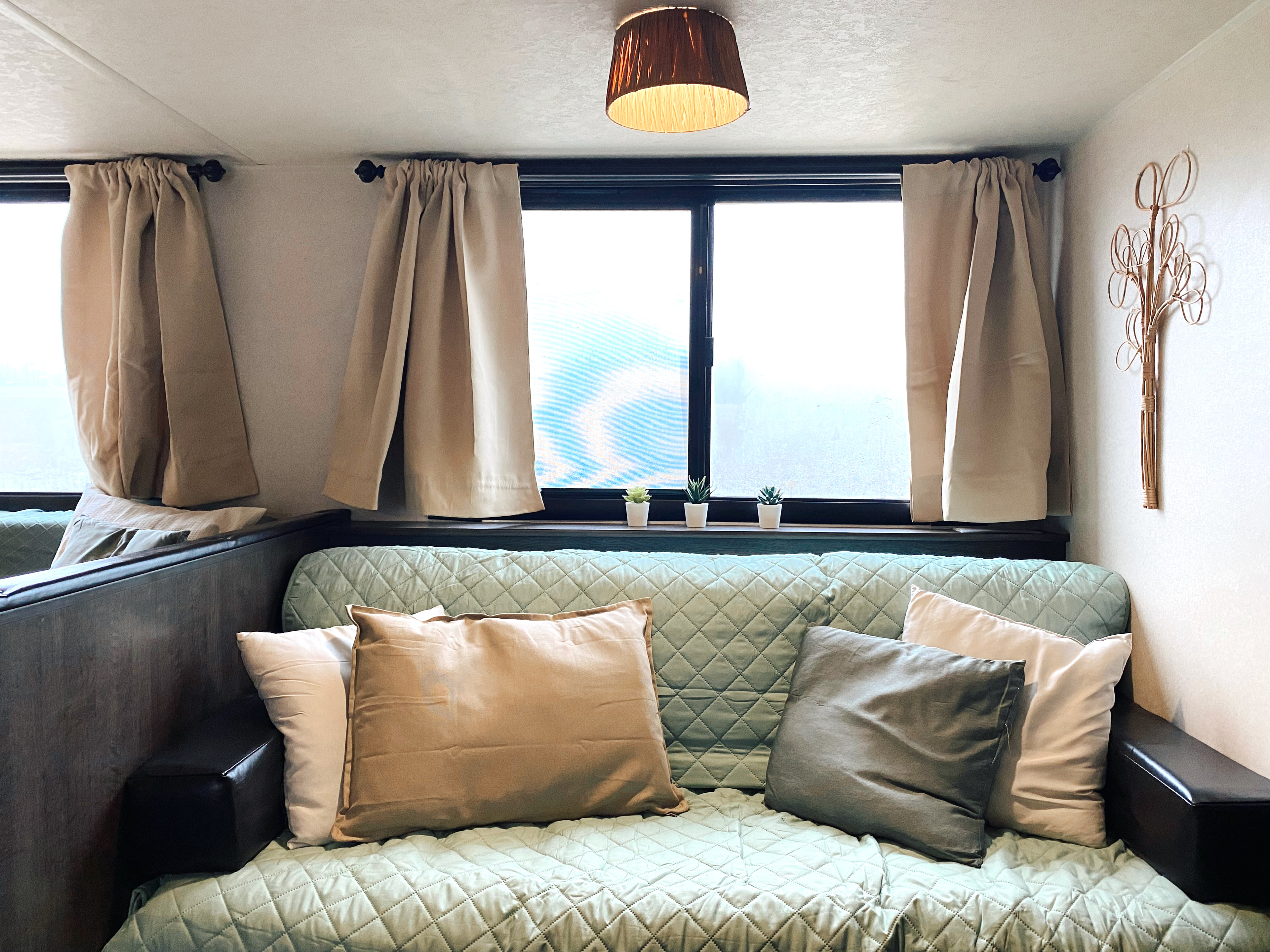 Cozy RV rental living space with a comfortable sofa, bright windows, and charming decor for your adventure.. Forest River Wildwood X-Lite 2019