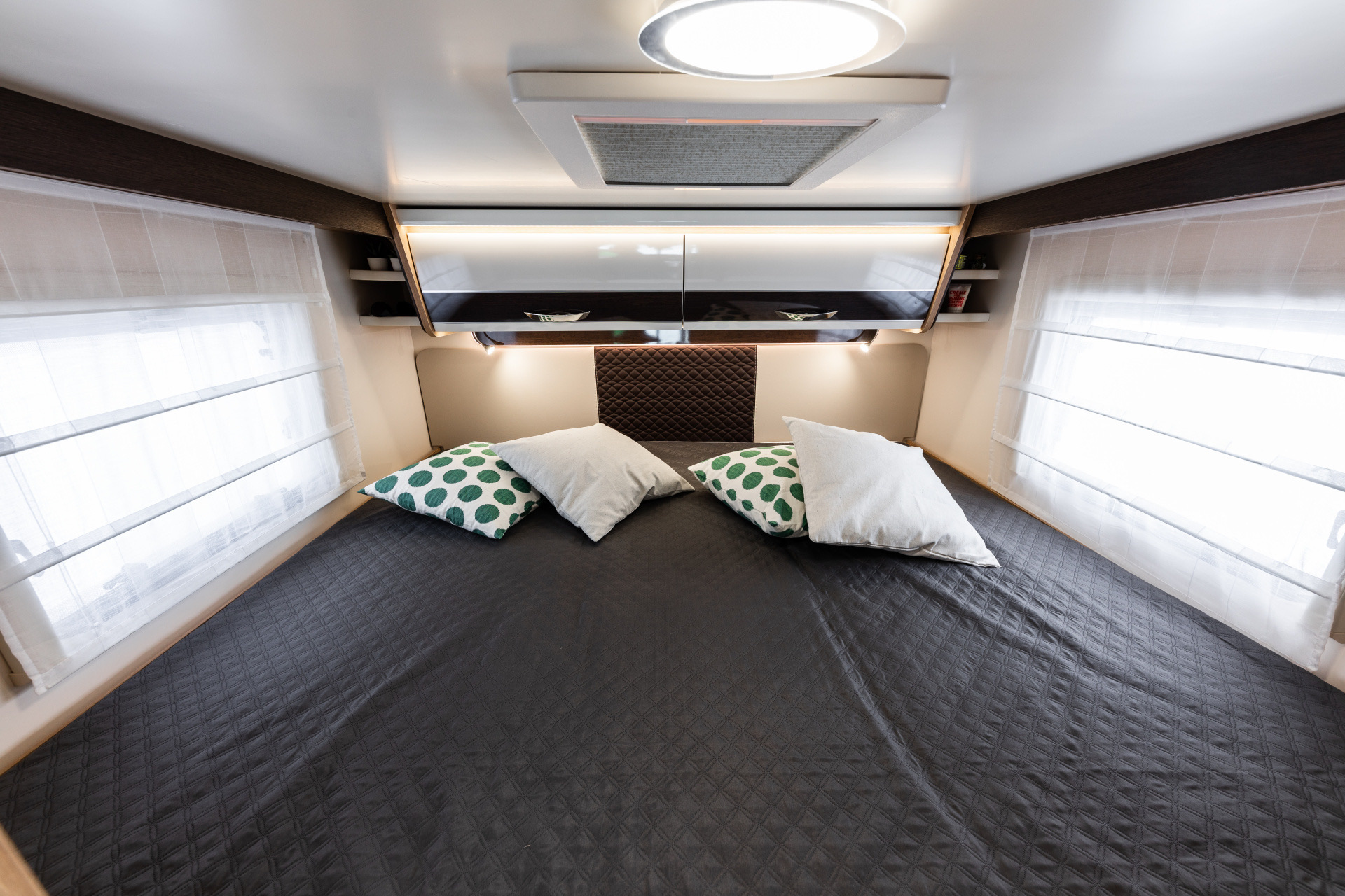 This comfy RV rental bedroom offers a spacious bed, bright windows, and modern storage, ideal for your next trip.. Elnagh Baron 565 2023