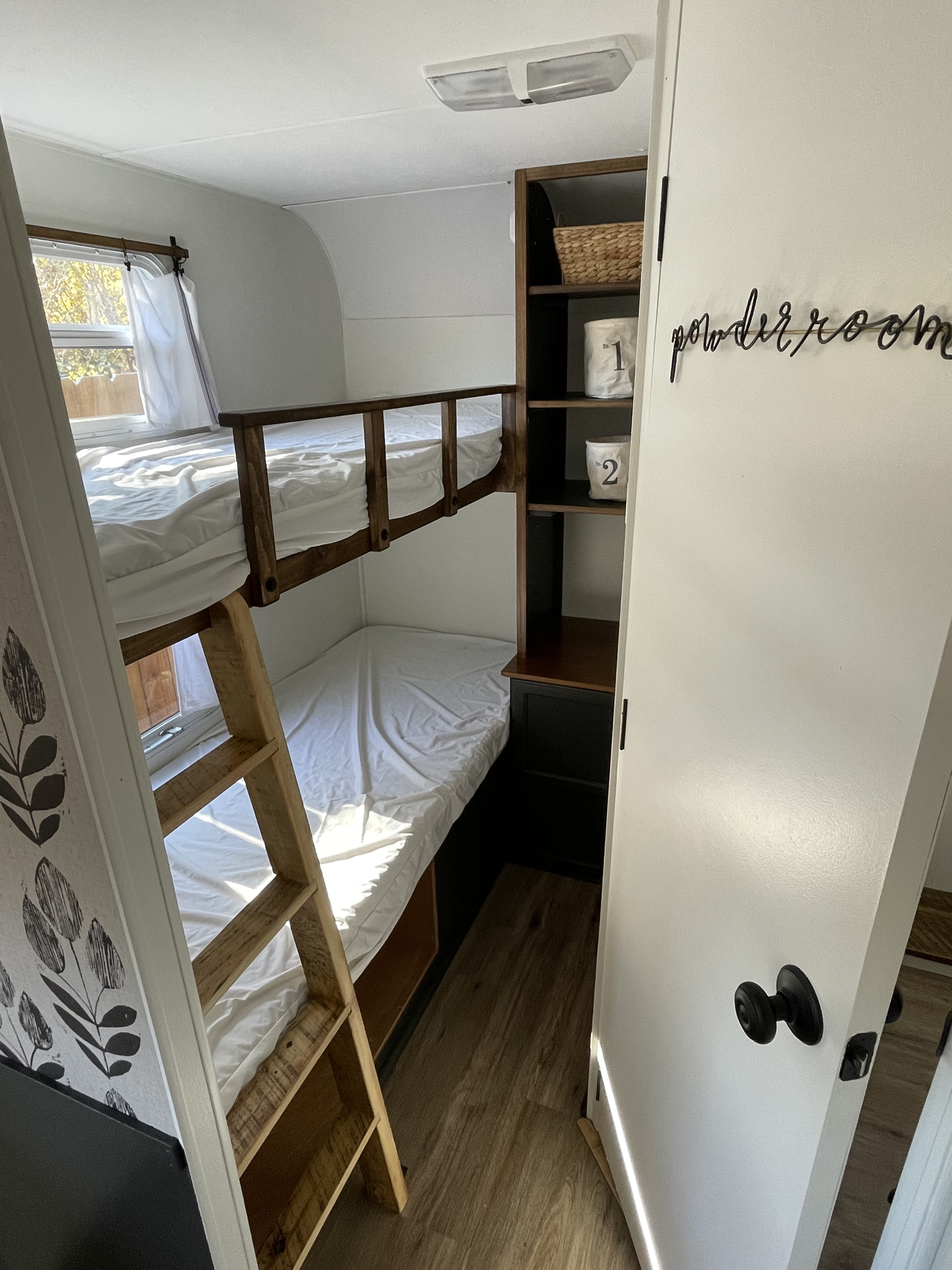 Functional RV rental bunk bed area with integrated storage and powder room access, showcasing a compact yet modern interior.. R-Vision 7000 Series 1999