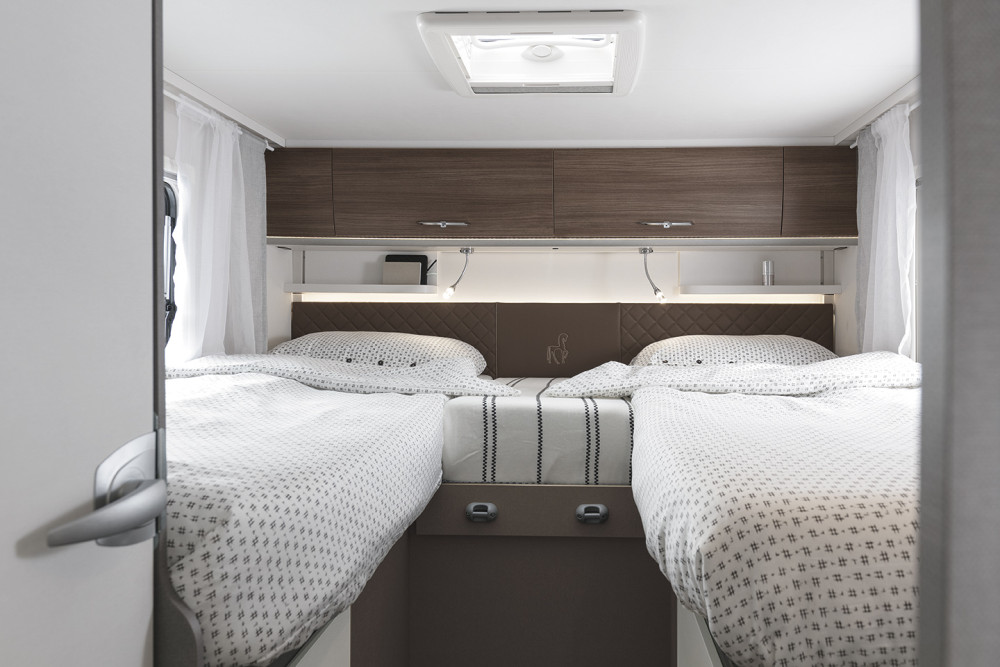 Comfortable rv rental bedroom with twin beds, overhead storage, reading lights, and a skylight. Ideal for travel.. Etrusco Etrusco T7400SBC 2021