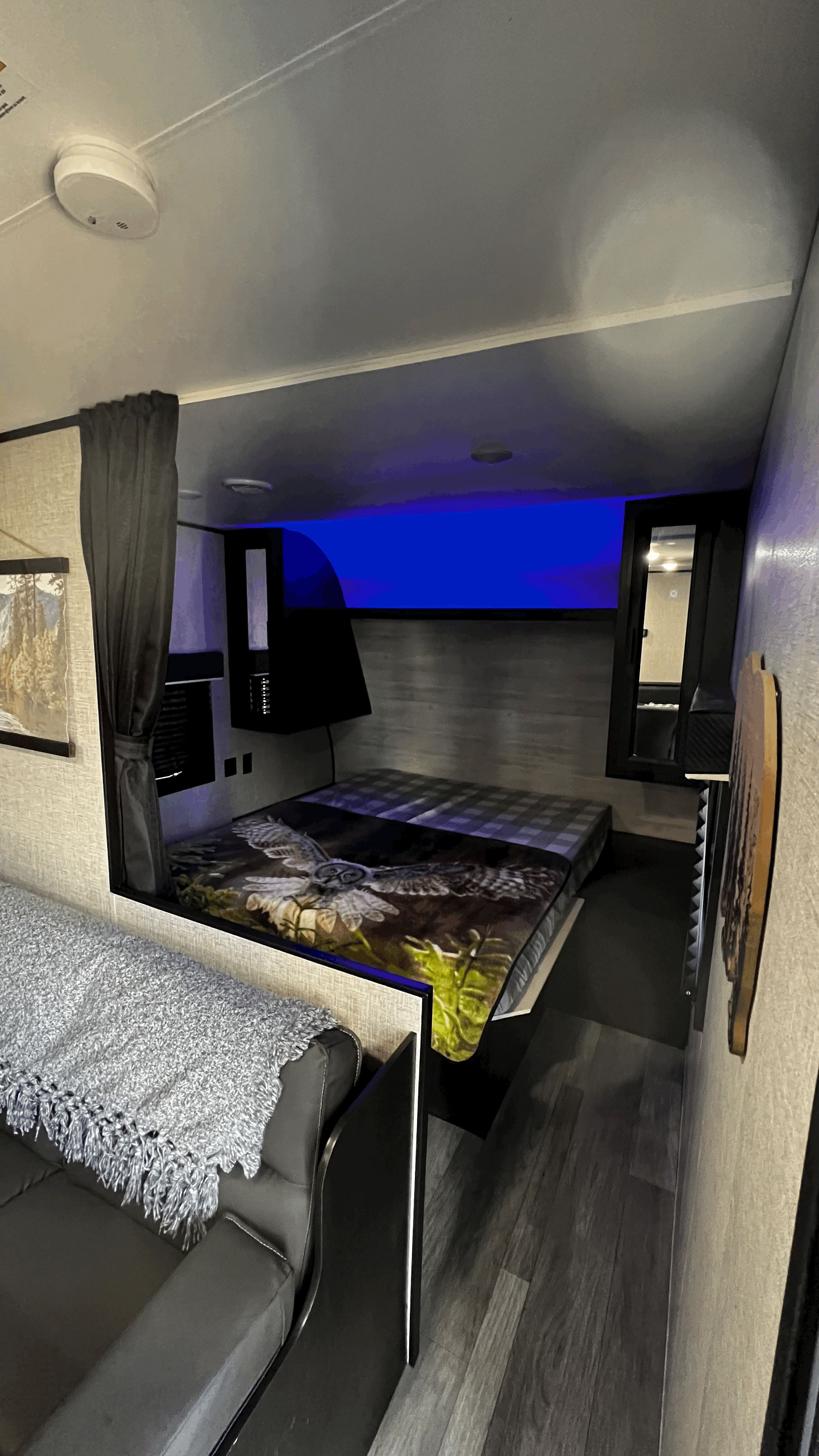 Cozy RV rental interior featuring a raised bed with unique blue light, sofa with blanket, and modern decor.. Jayco Jay Flight SLX 2022