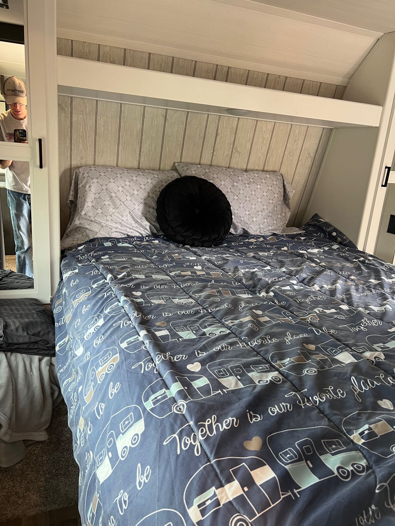 Inside a comfy RV rental, showing a bed with a fun camper-themed comforter.. Keystone Hideout 2022