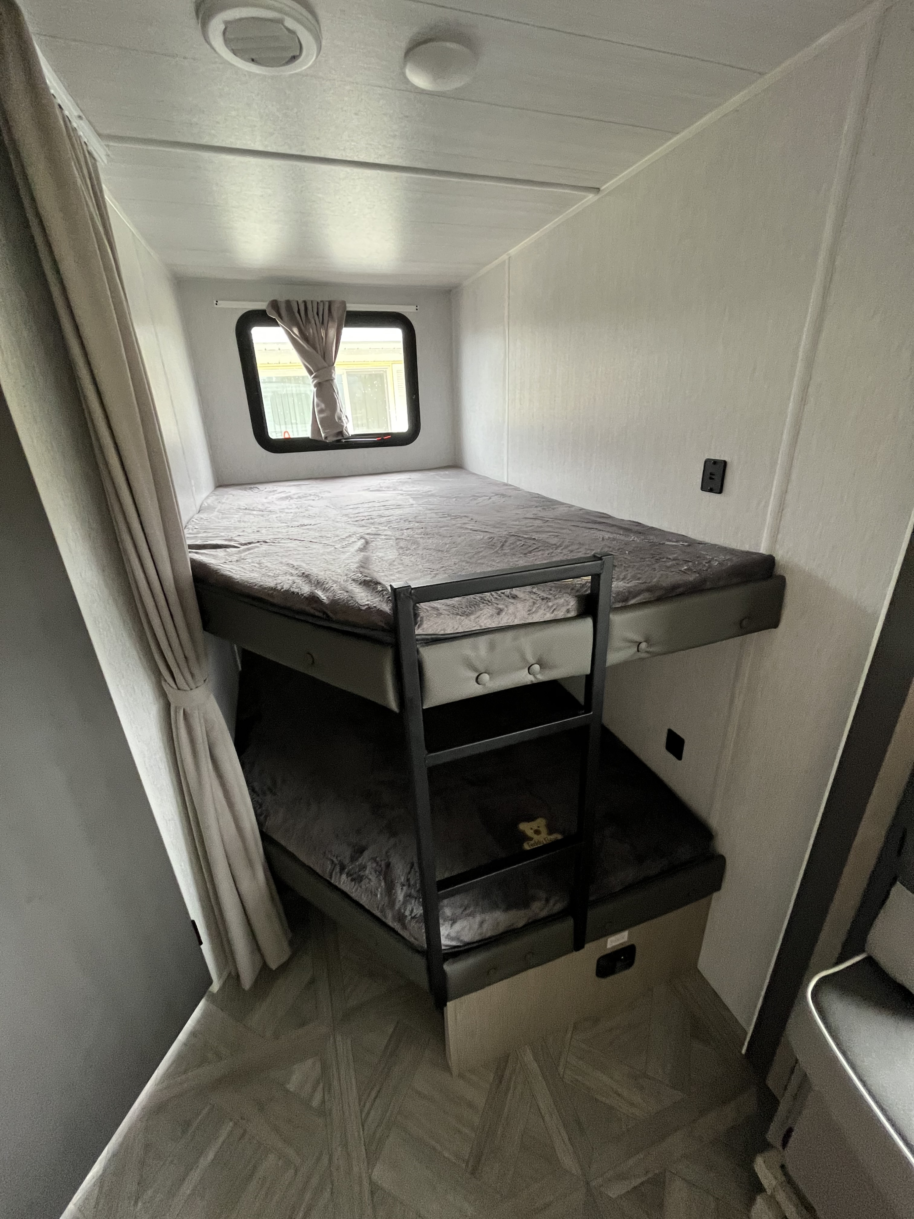 RV rental: Interior shows twin bunk beds, a window, & wood-look floor, ideal for family trips.. Wildwood X-Lite BH 263 2023