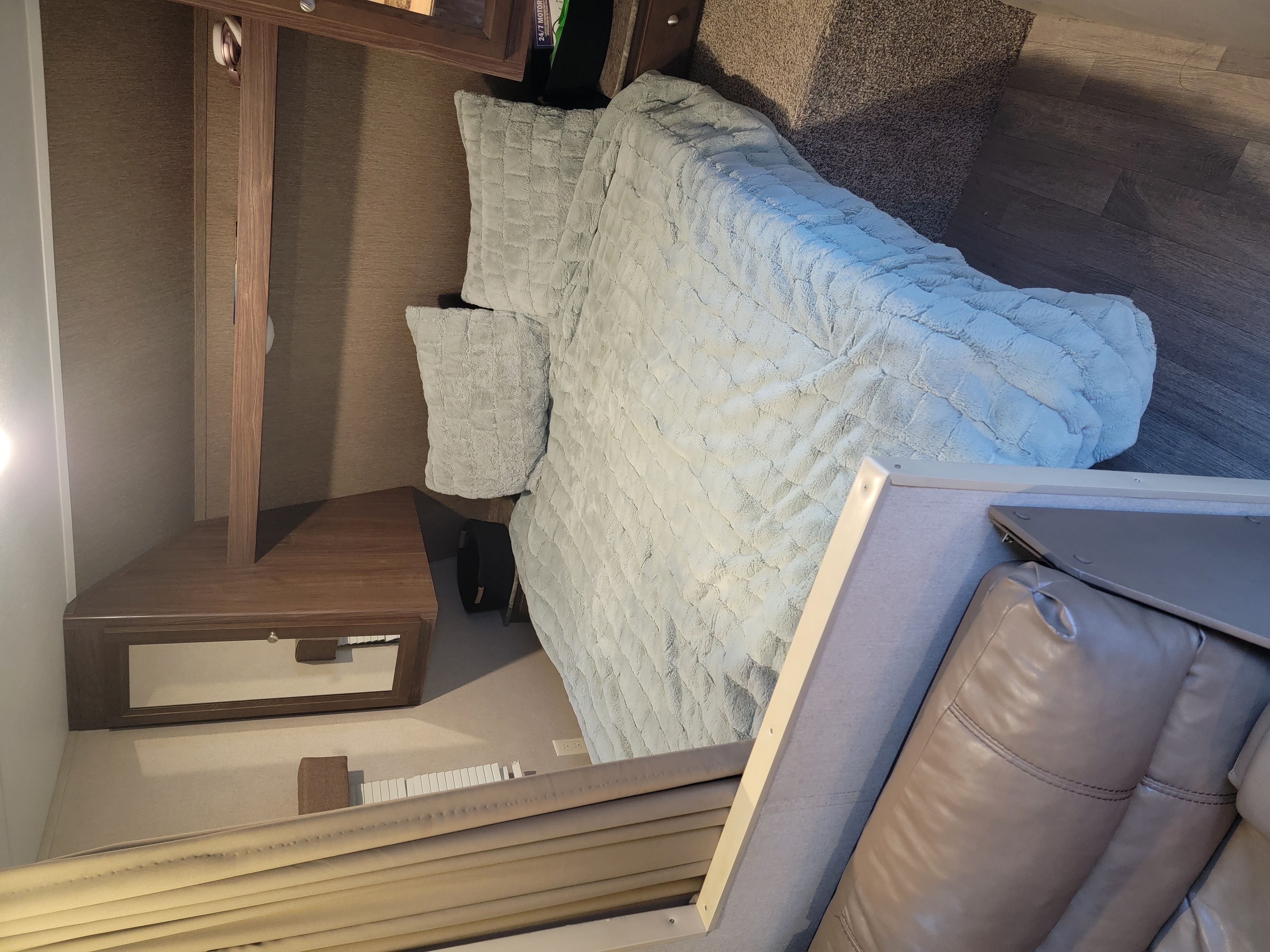 Inside a comfy RV rental: plush bed, cozy living area, and wood furnishings for a relaxing trip.. Dutchmen Coleman Lantern 2016