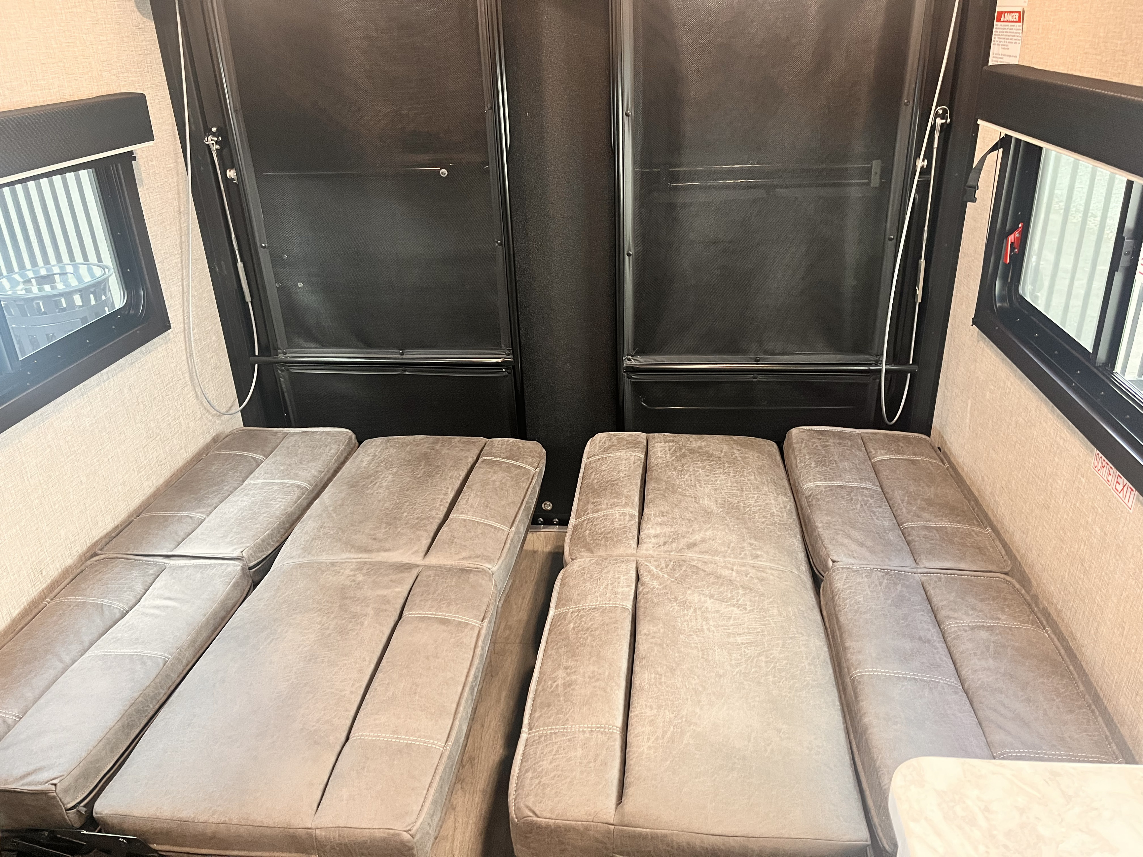 RV rental interior: two rows of gray convertible sofa beds below a black pull-down bunk system.. Jayco Jay Flight 2022